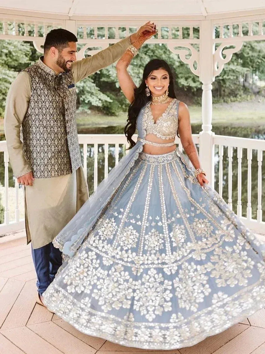 Elegant blue lehenga choli with intricate embroidery, paired with a matching dupatta and traditional jewelry for Indian weddings.