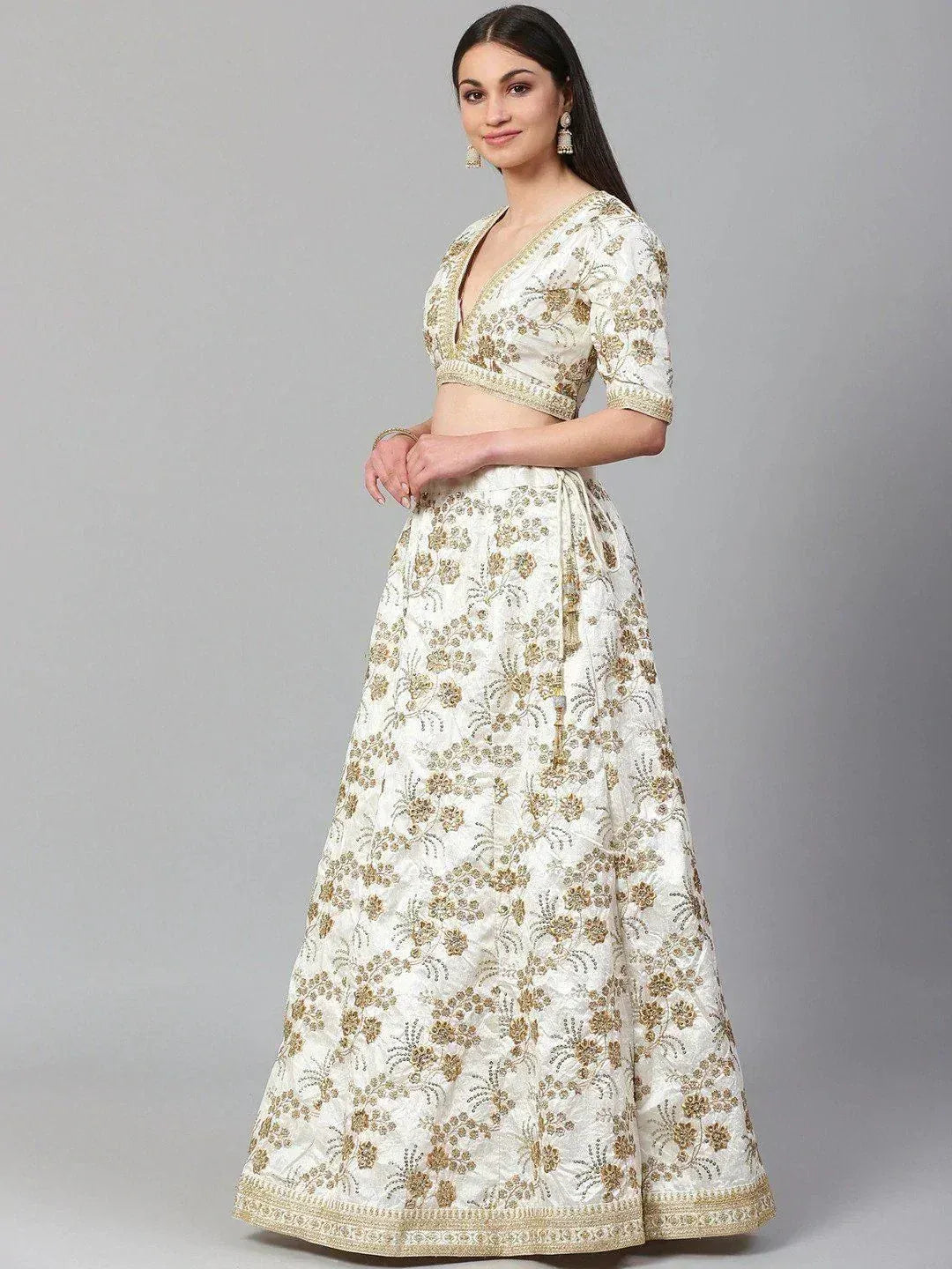 Elegant white and gold embroidered lehenga choli with floral motifs, perfect for Indian ethnic occasions.