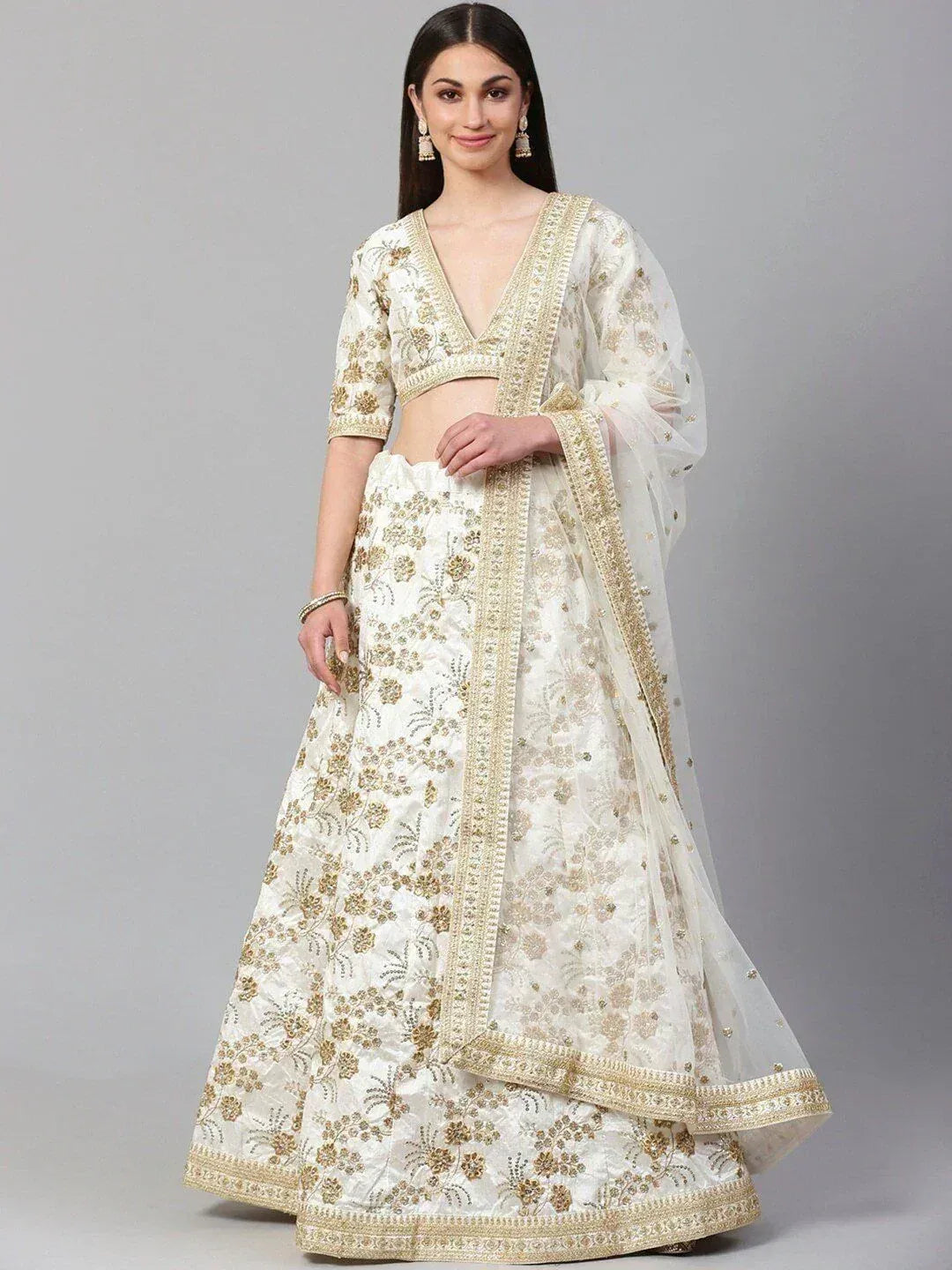 White and gold embroidered lehenga choli with floral design, perfect for weddings and festive occasions.