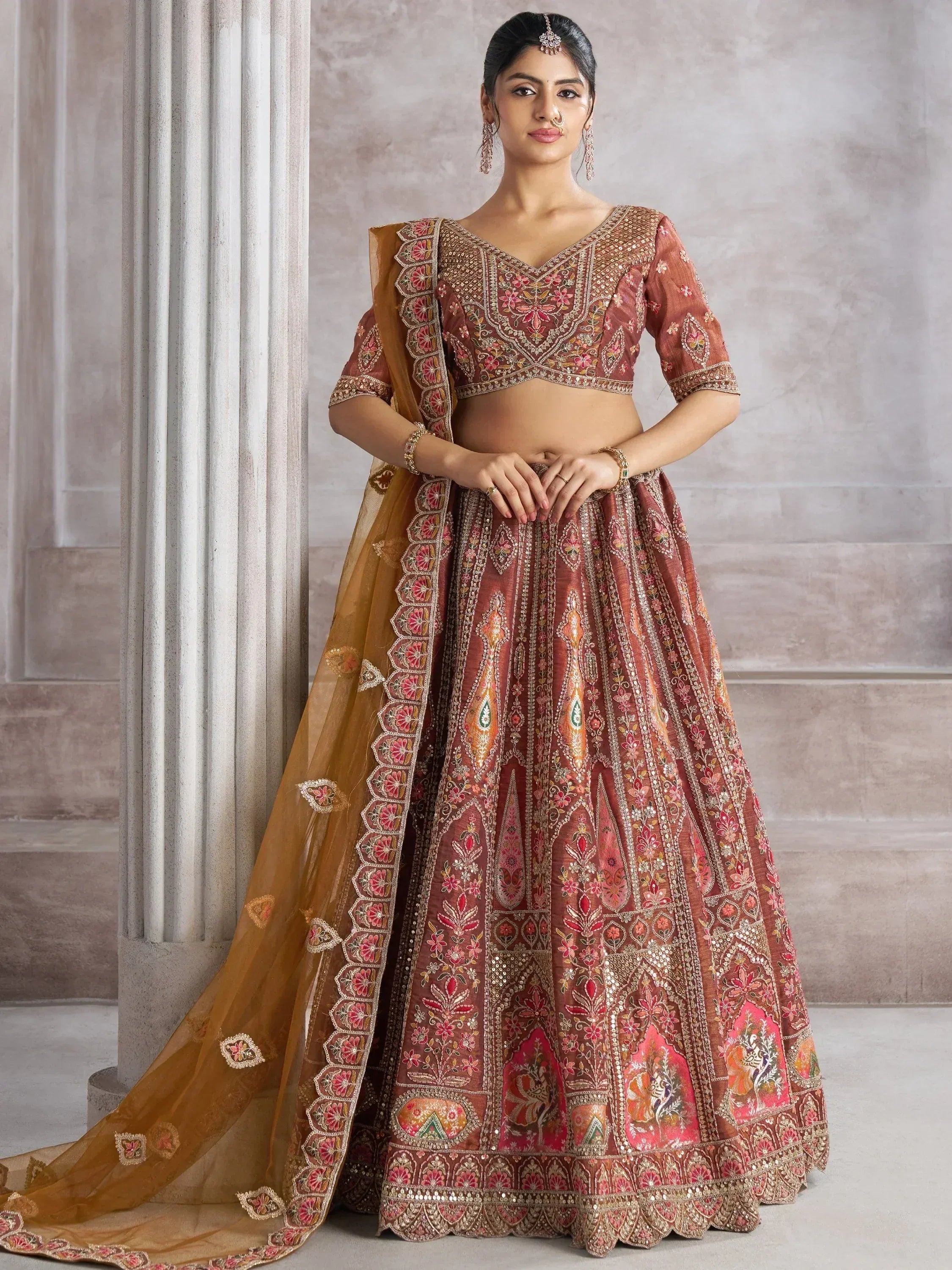 Elegant maroon lehenga choli with floral embroidery and gold detailing, perfect for Indian weddings or festive occasions.