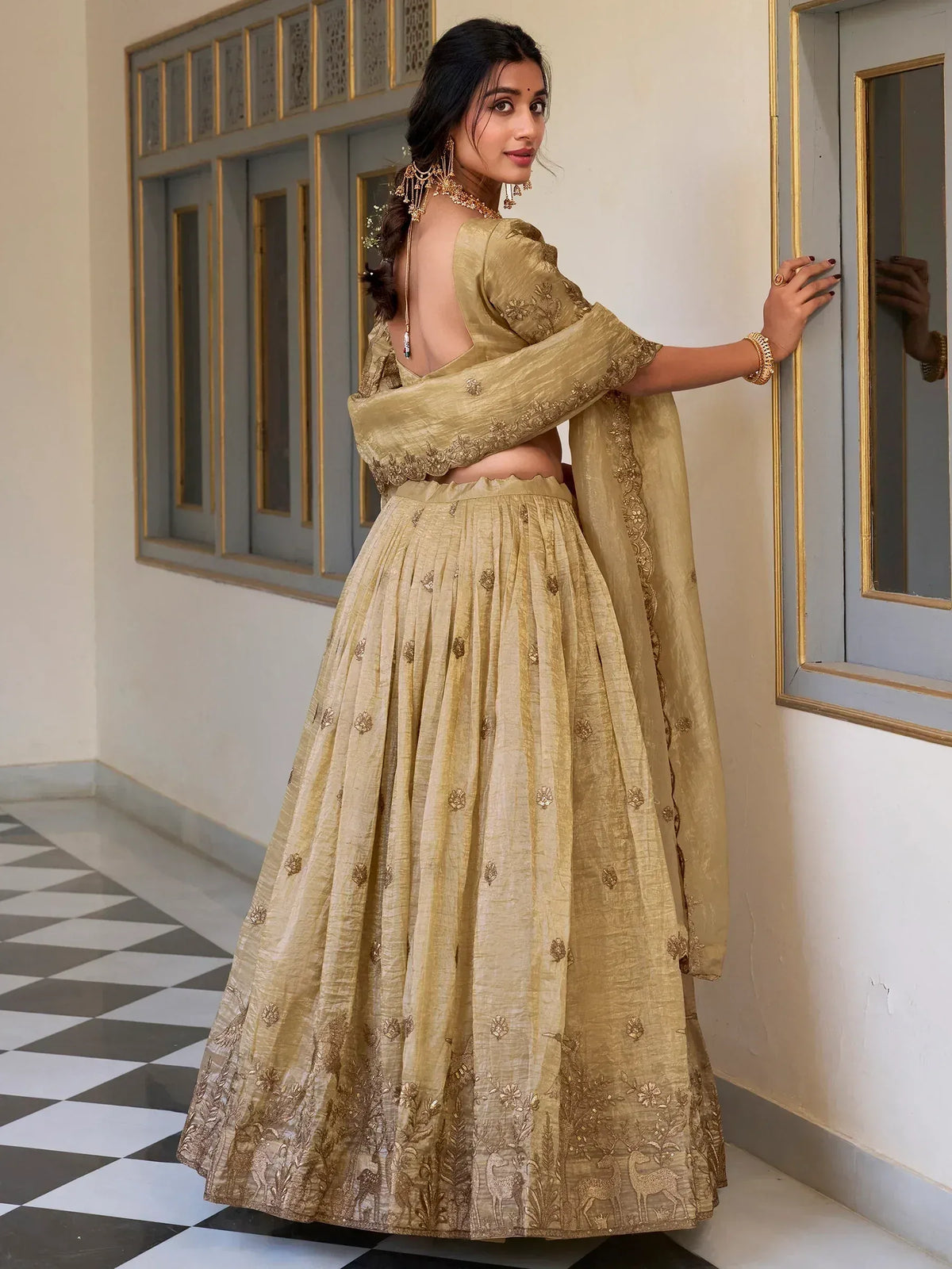 Elegant gold lehenga choli with floral and deer embroidery, perfect for Indian ethnic occasions.