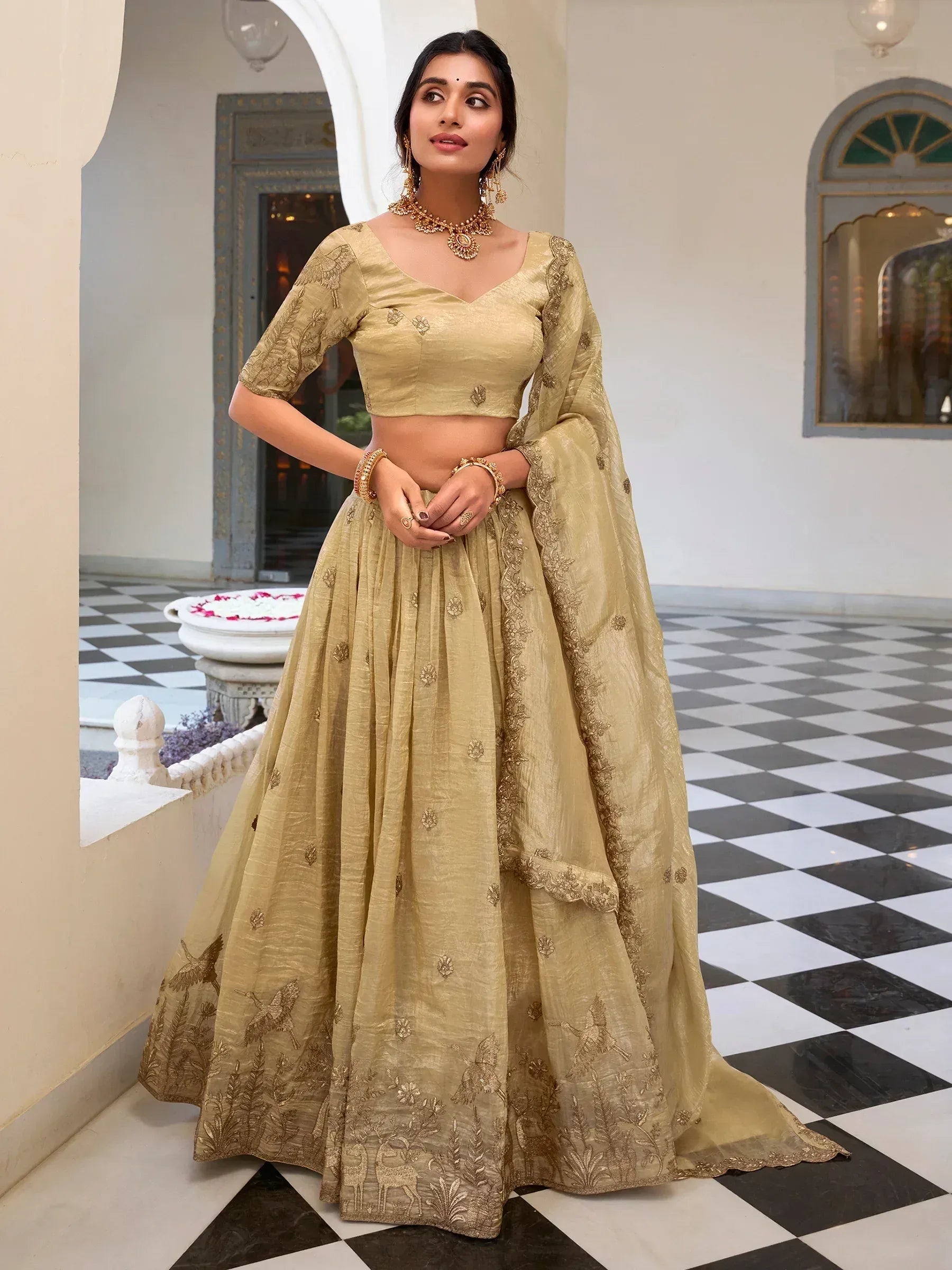 Elegant gold embroidered lehenga choli with bird and deer motifs, perfect for Indian ethnic wear occasions.