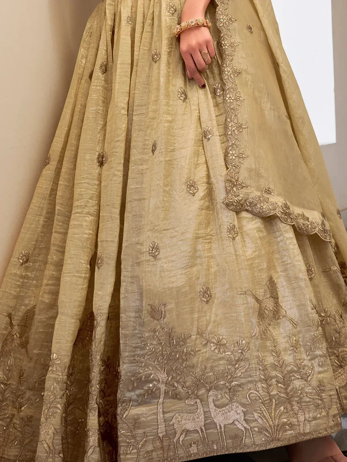 Elegant gold lehenga with deer and bird embroidery, perfect for Indian ethnic wear occasions.