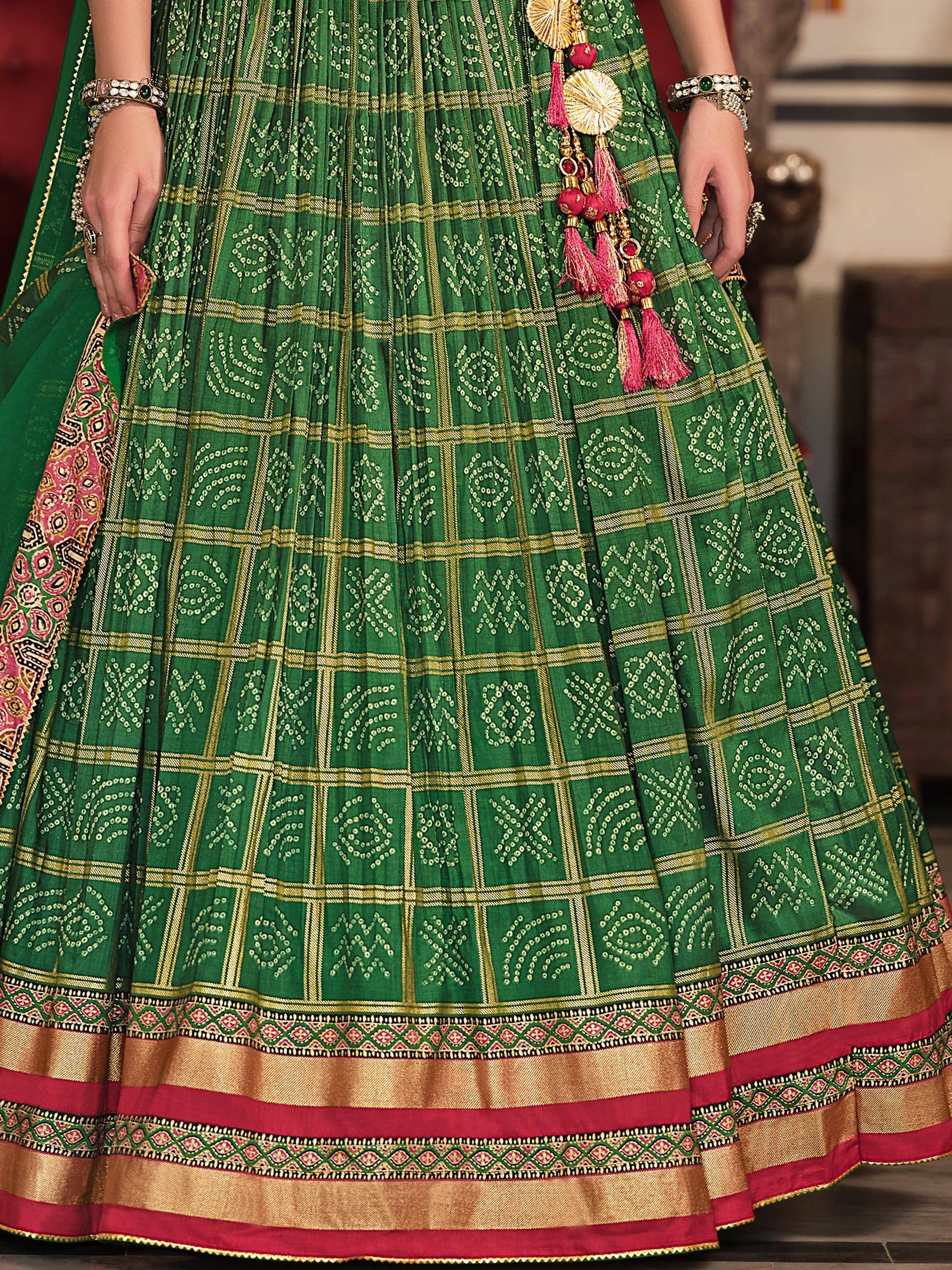 Green ethnic lehenga with gold embroidery, pink tassels, and traditional Indian print for festive wear