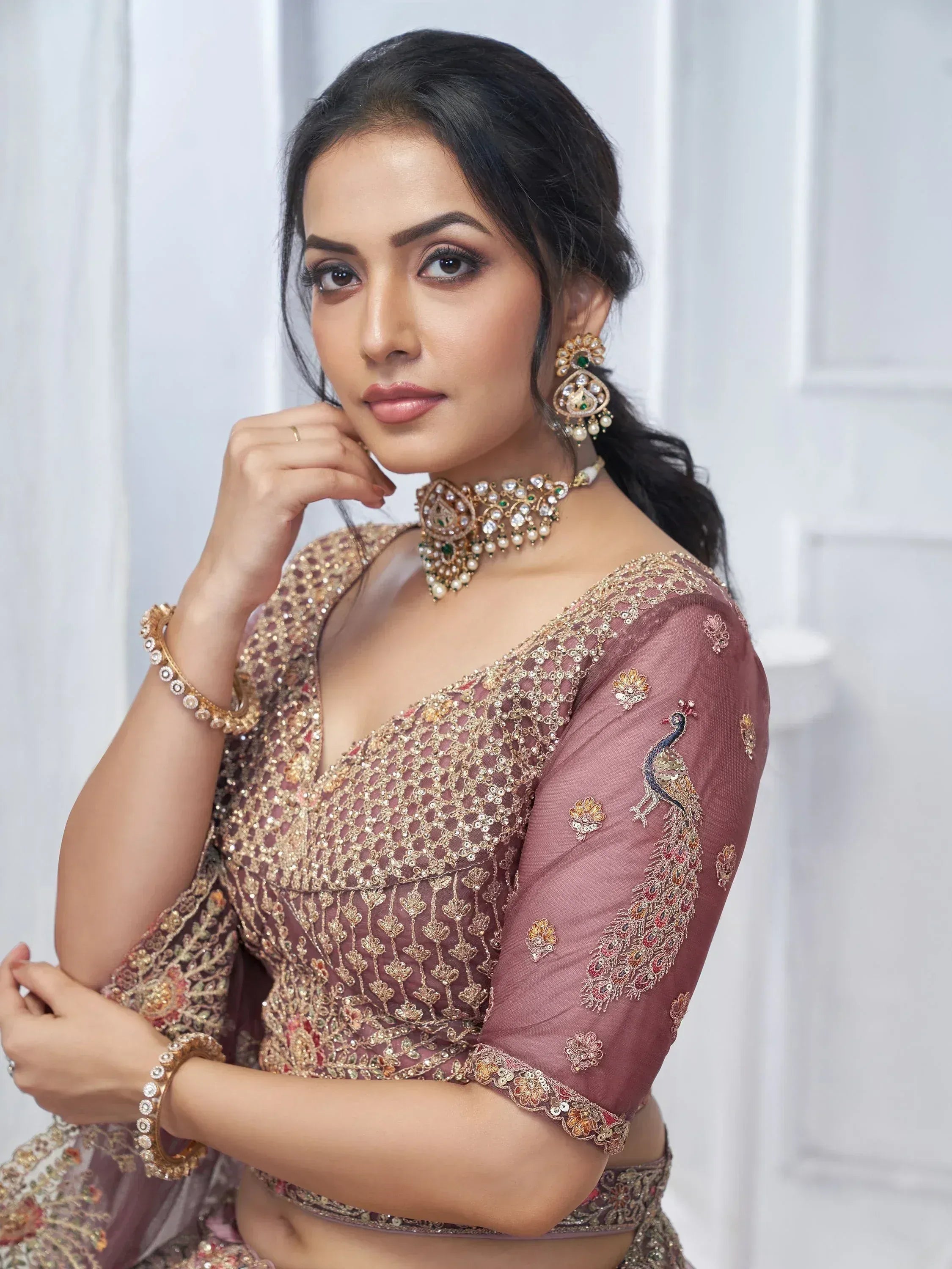 Elegant Indian ethnic wear with peacock embroidery, gold detailing, and traditional jewelry for festive occasions