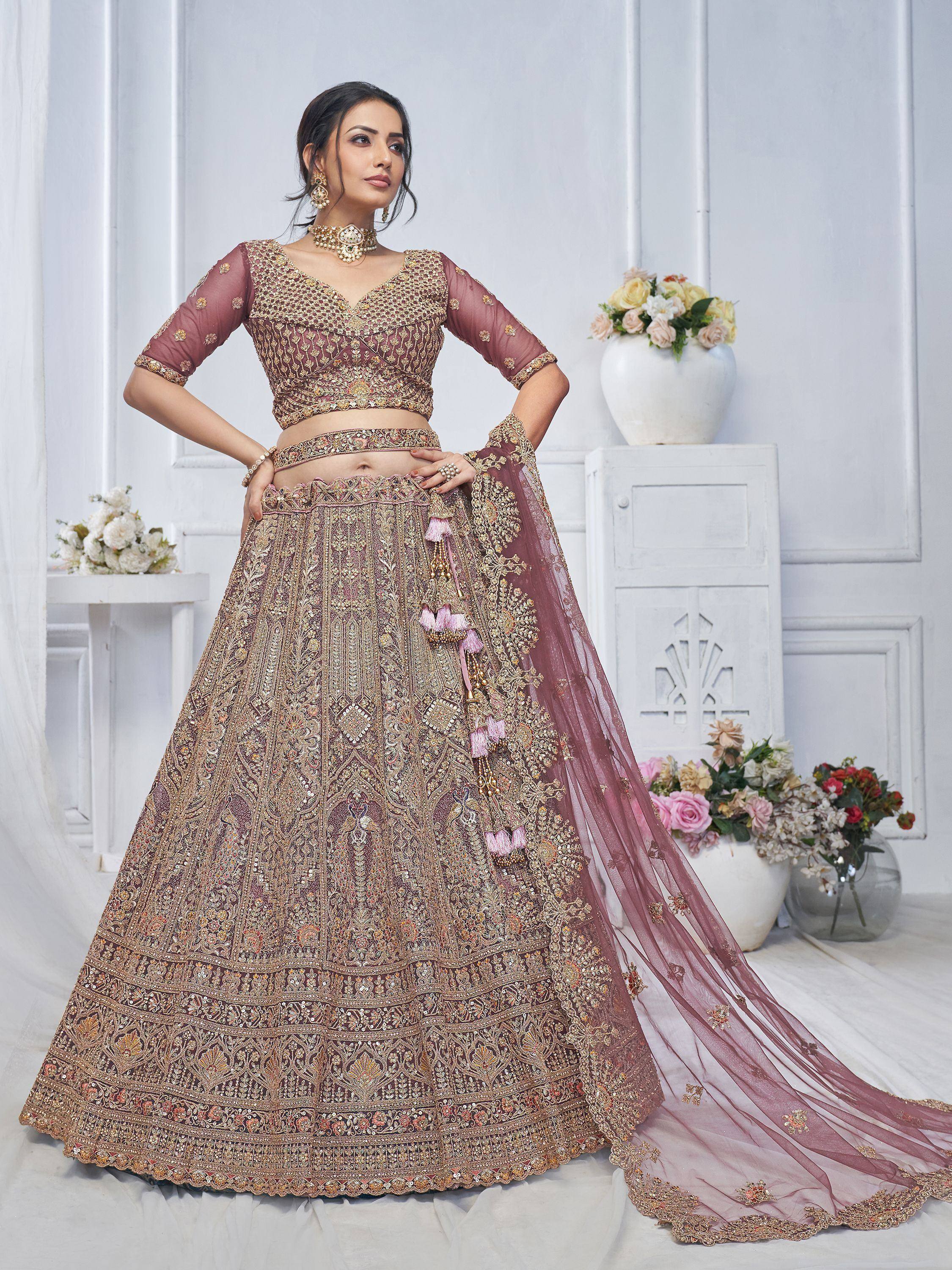 Elegant mauve lehenga choli with heavy gold embroidery and tassels, perfect for Indian weddings and festive occasions.