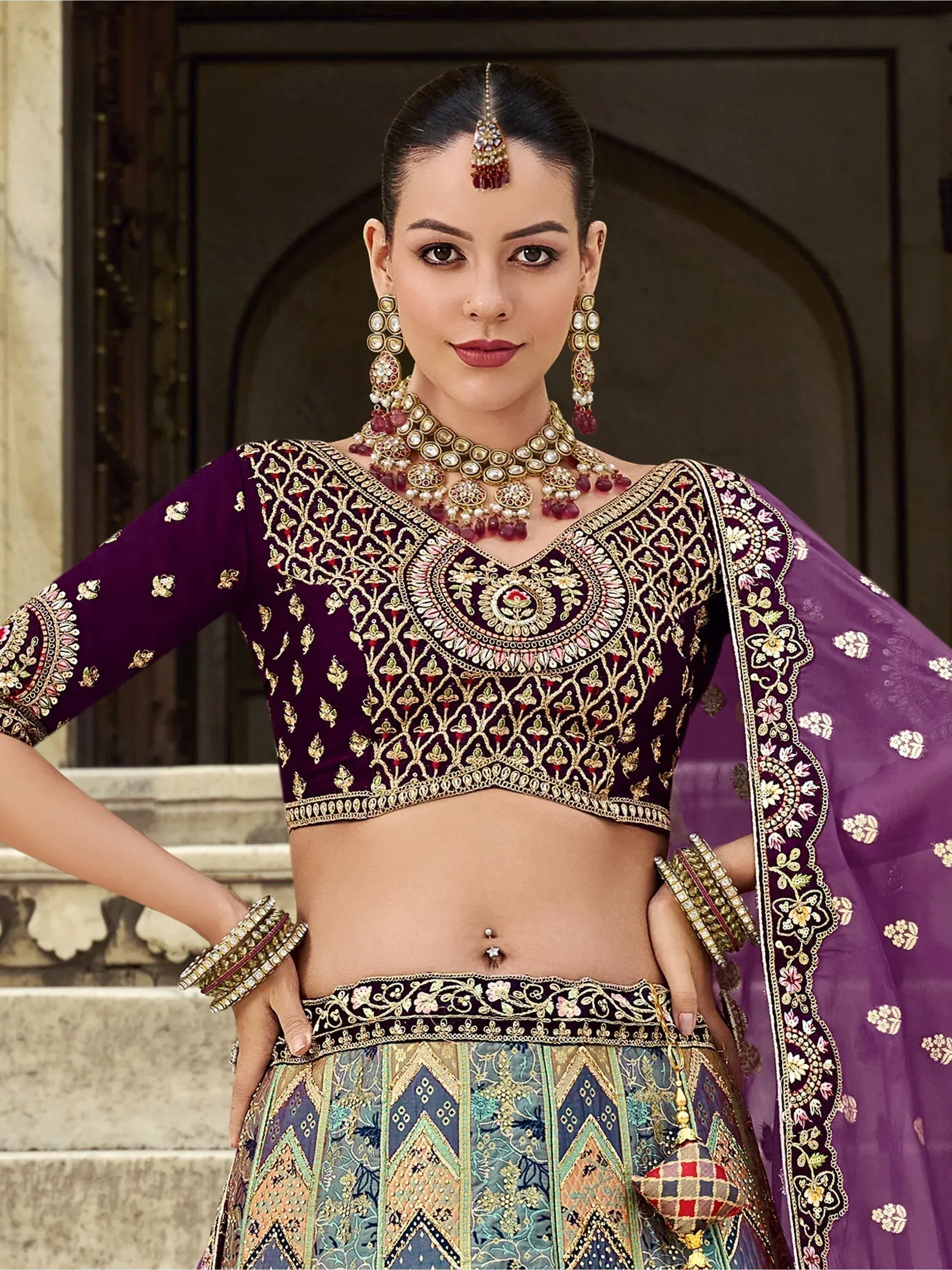Elegant purple embroidered lehenga choli with gold detailing, perfect for Indian weddings and festive occasions.
