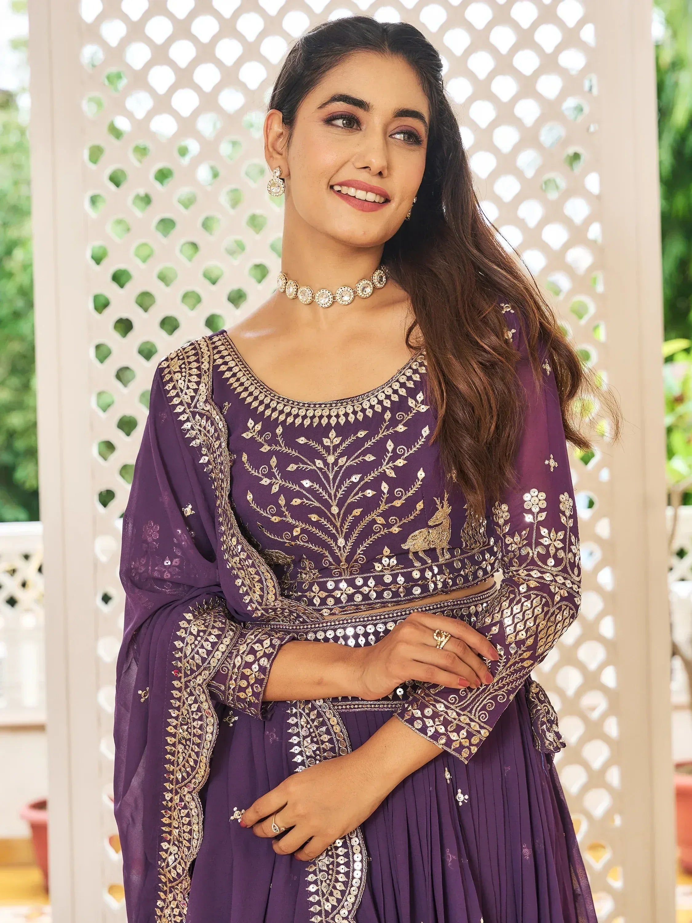Purple embroidered ethnic lehenga choli with gold detailing and mirror work, perfect for Indian weddings or festive occasions.