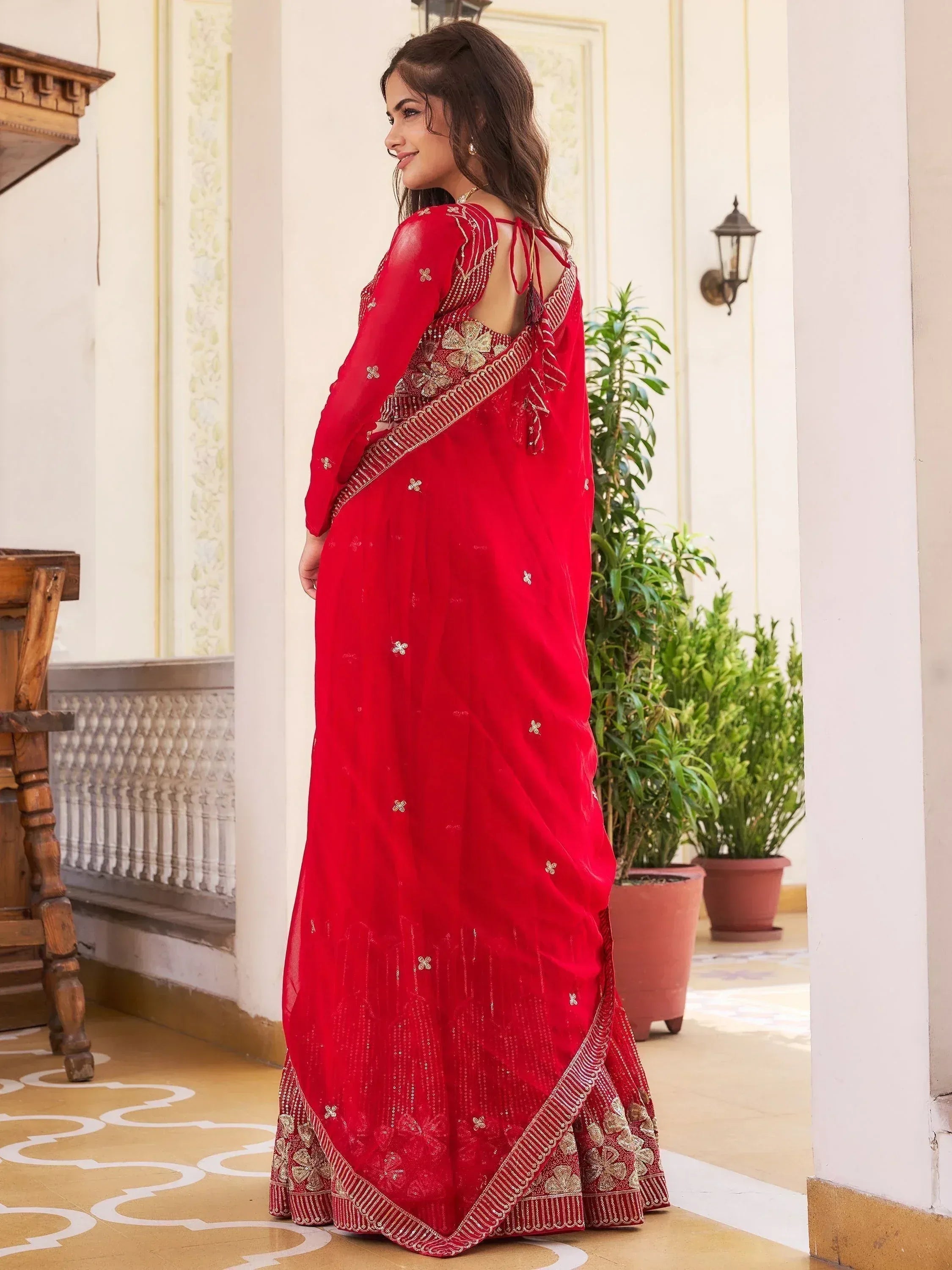 Red embroidered saree with gold detailing, backless blouse, ethnic Indian wear for weddings or parties