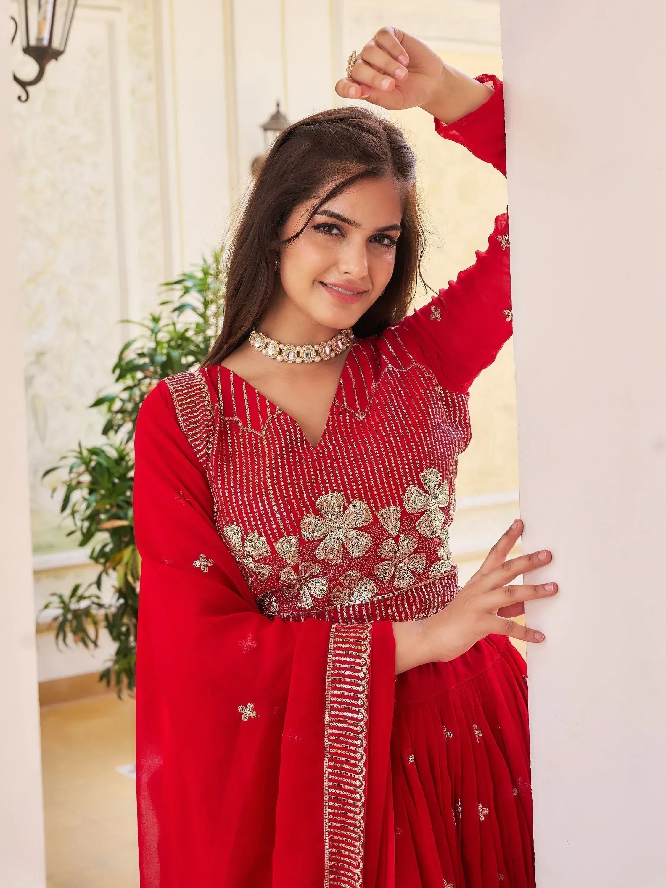 Red embroidered ethnic gown with gold detailing, perfect for Indian festive occasions and weddings.