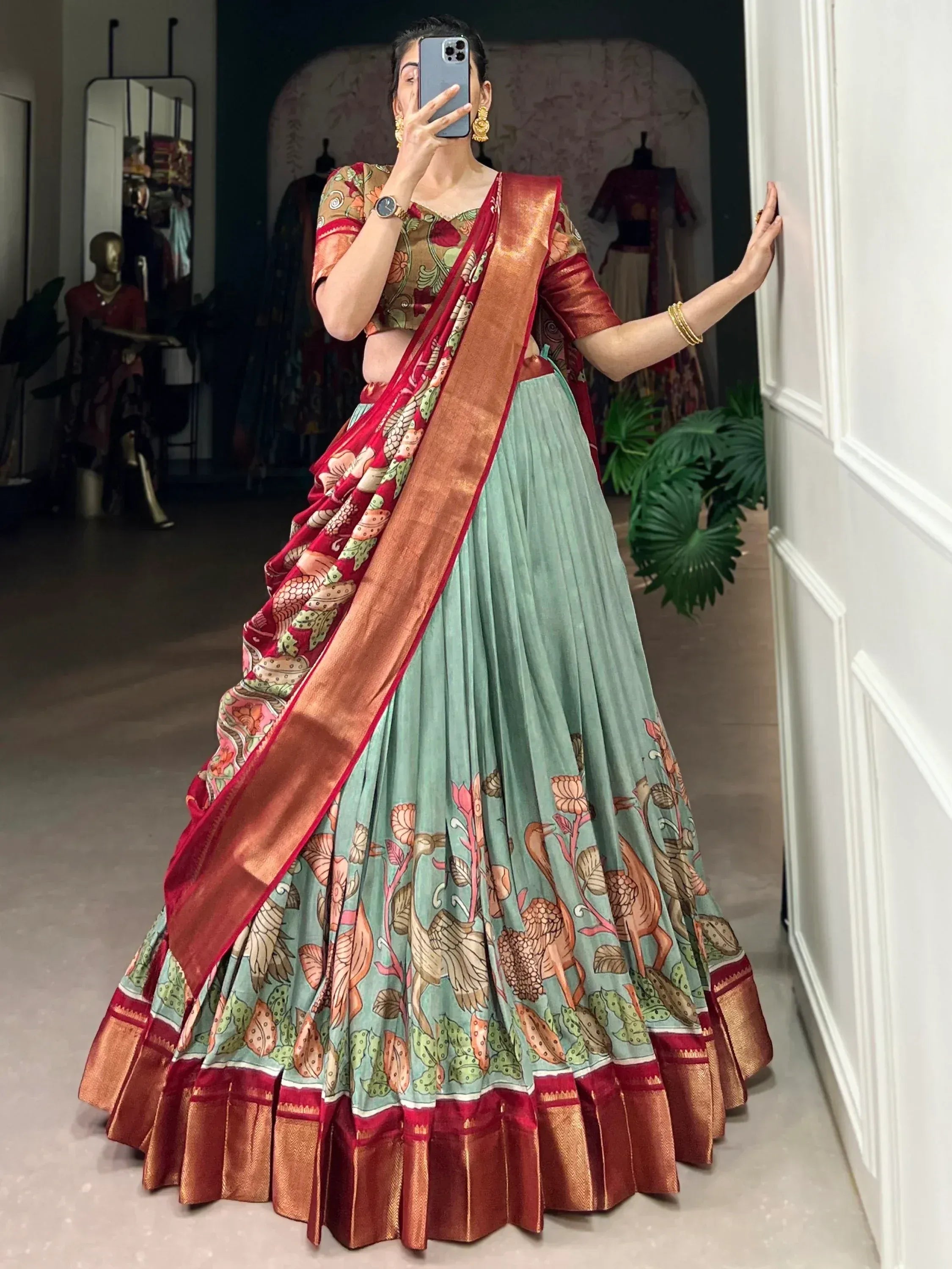 Woman in floral print lehenga choli with red border, ethnic Indian wear for festive occasions