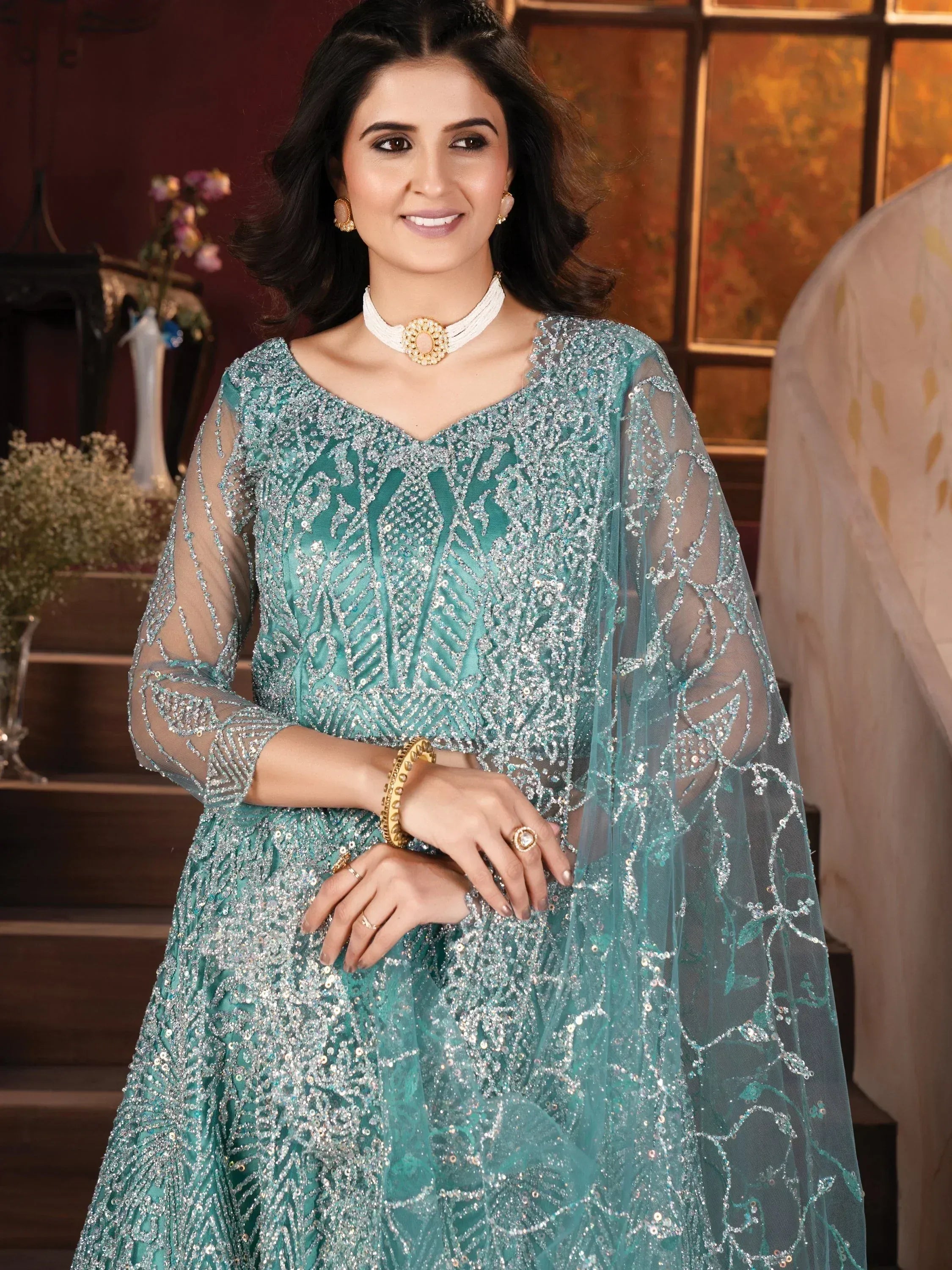 Teal sequin-embellished Indian ethnic gown with sheer sleeves, perfect for weddings and festive occasions.