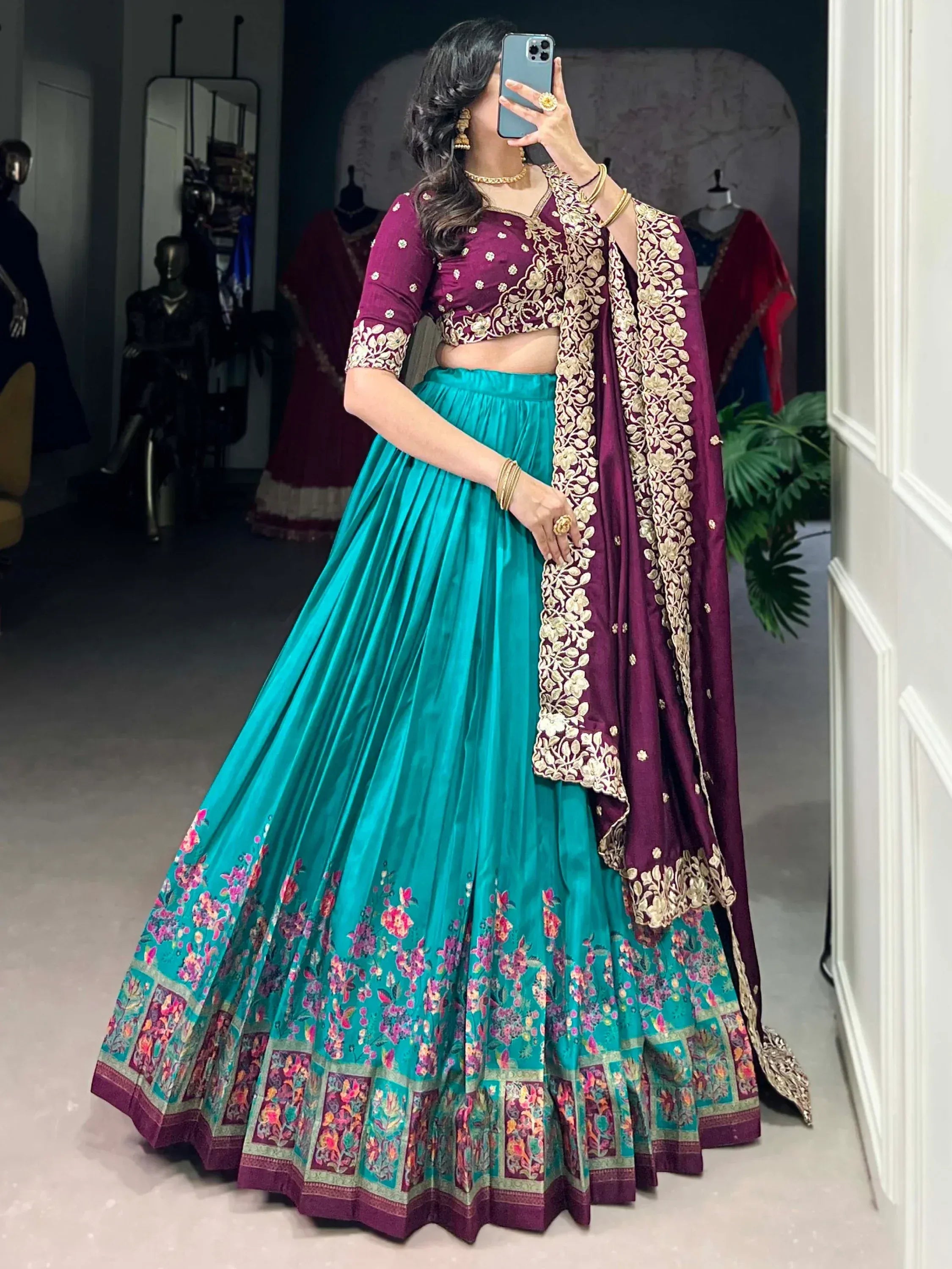 Teal and maroon designer lehenga choli with gold embroidery, floral border, and matching dupatta for Indian ethnic wear