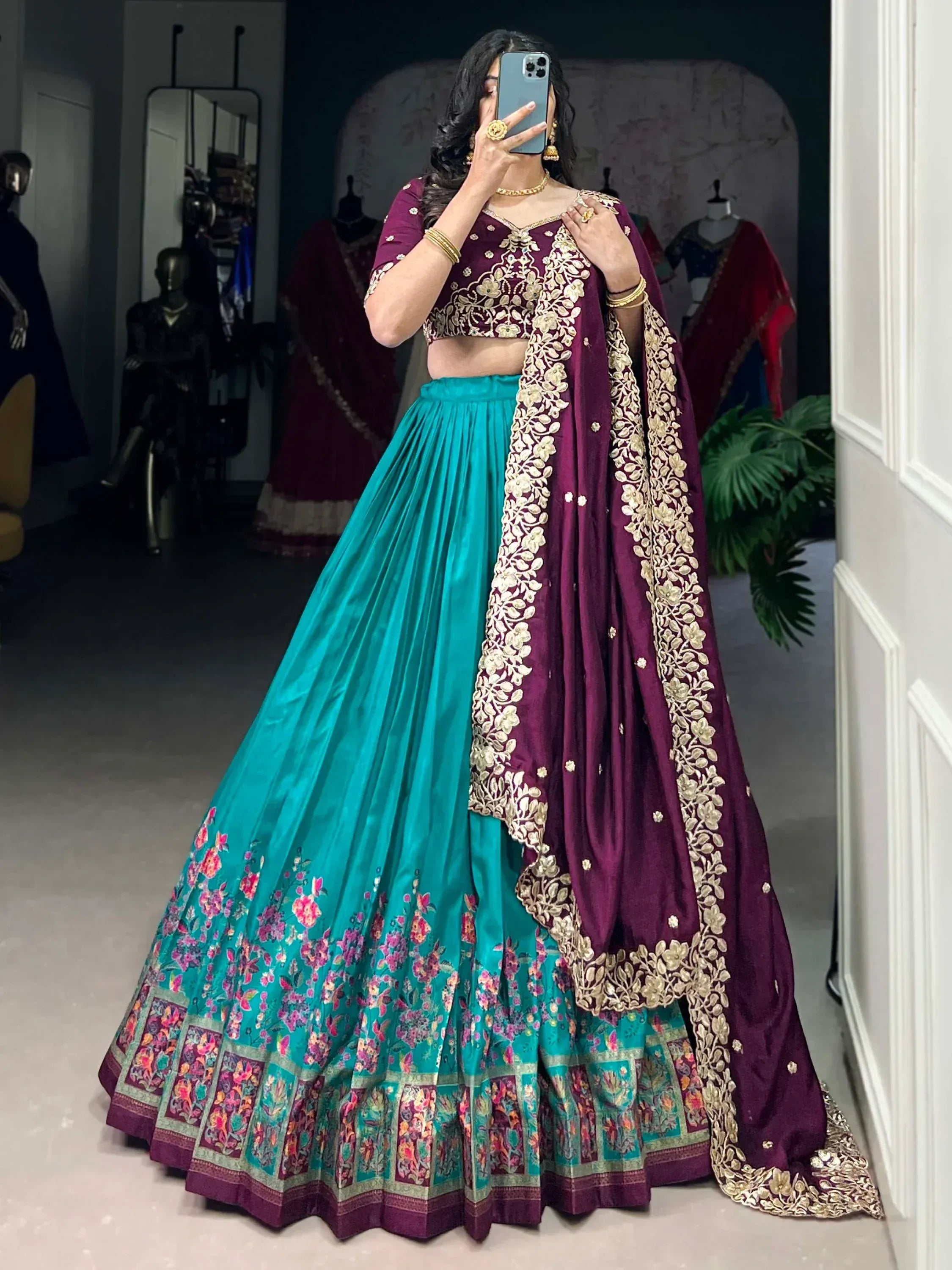 Purple and teal designer lehenga choli with gold embroidery, floral border, perfect for Indian weddings or festive occasions.