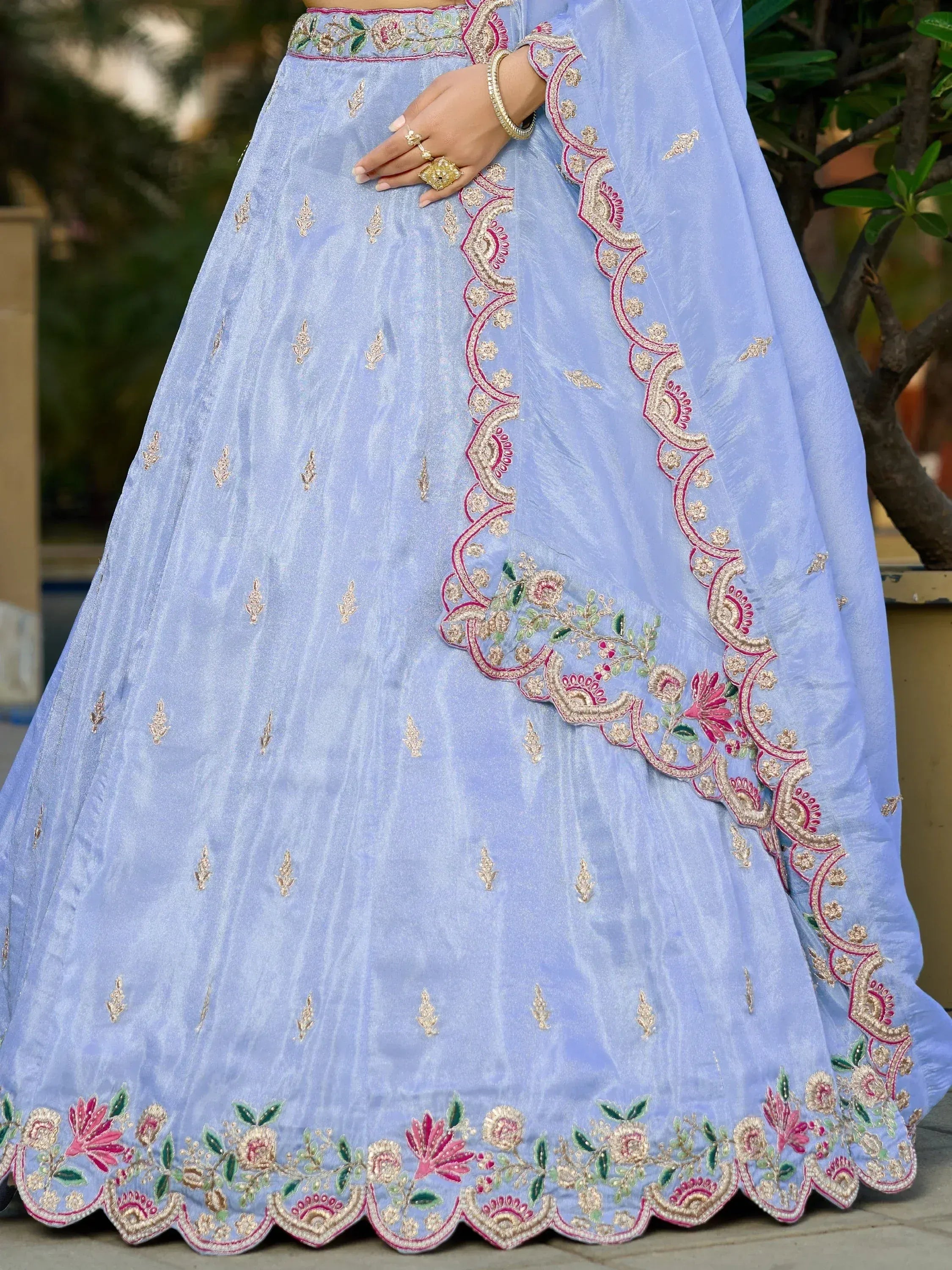 Light blue embroidered lehenga with floral gold and pink detailing, perfect for Indian ethnic wear occasions.