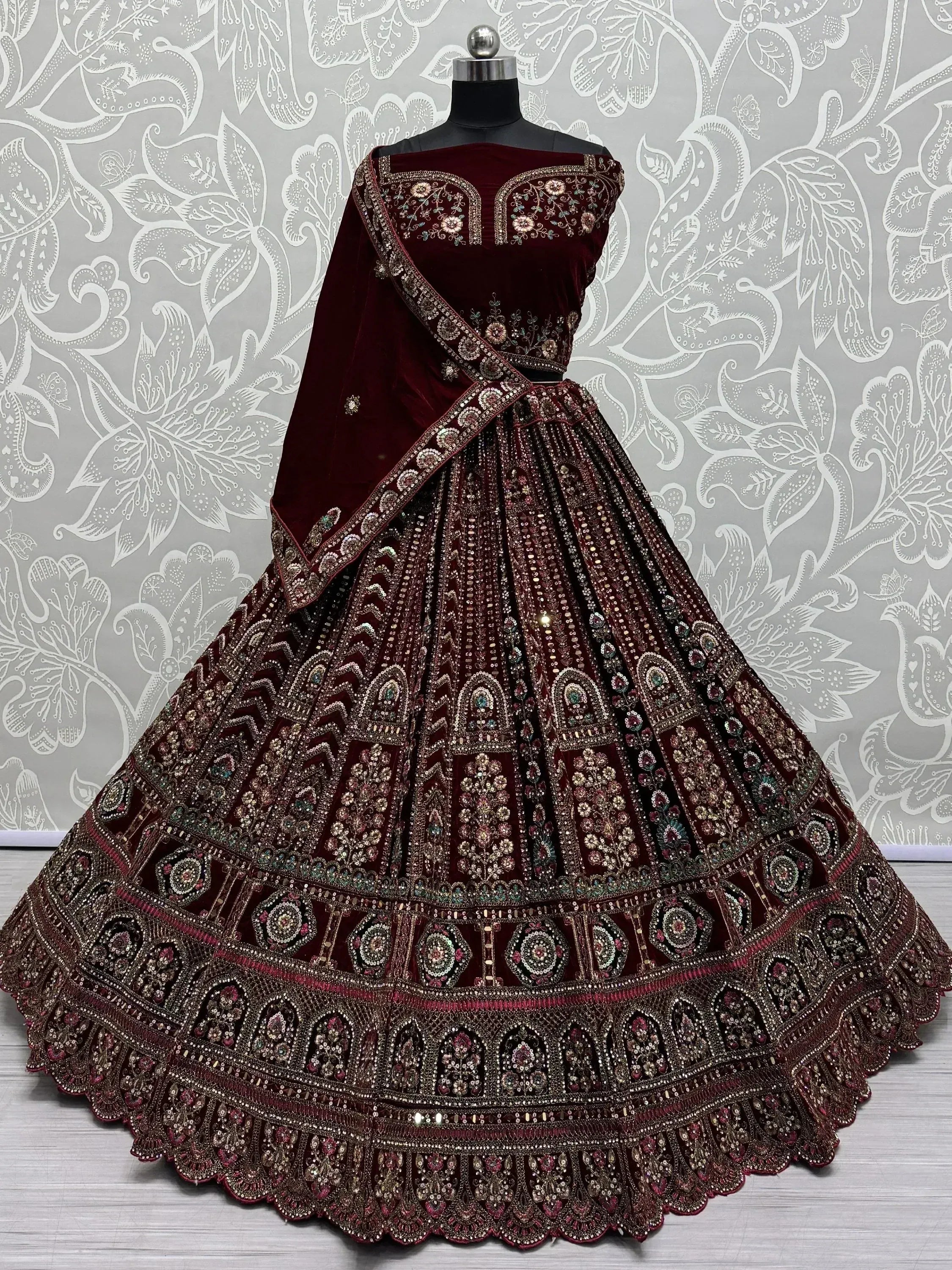 Maroon velvet designer lehenga choli with heavy embroidery and sequins, perfect for Indian weddings and festive occasions.