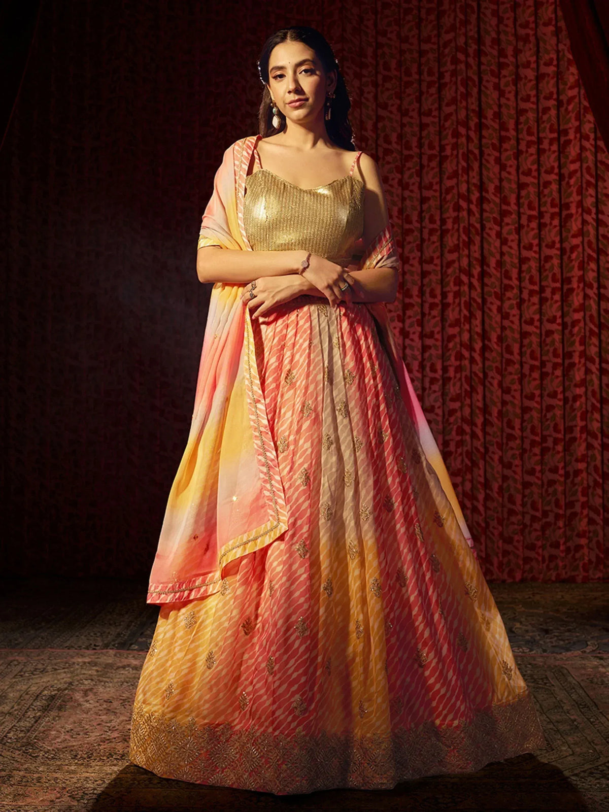 Woman in peach and gold designer lehenga choli with sequin top and embroidered skirt, perfect for Indian weddings