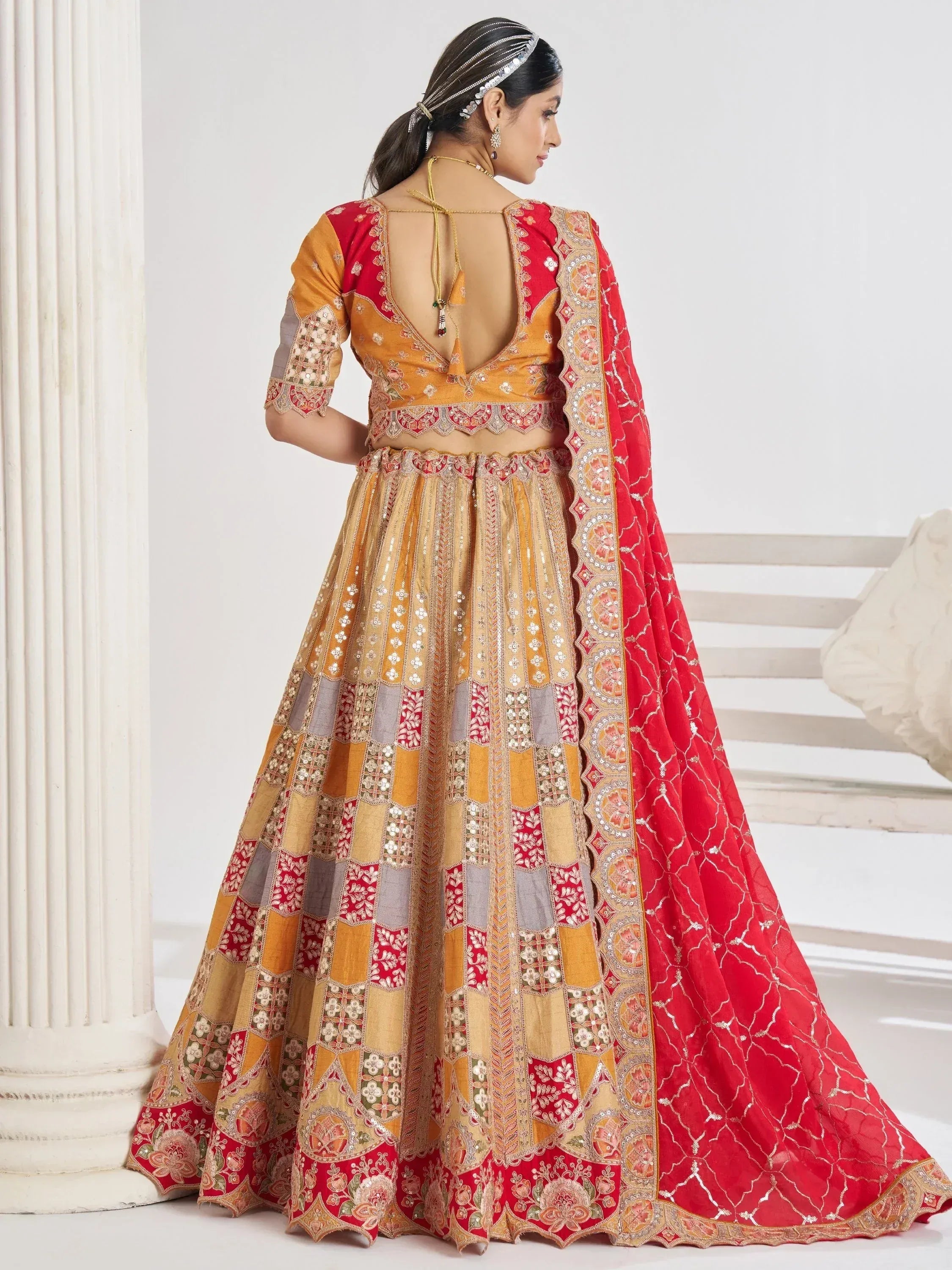 Red and gold designer lehenga choli with intricate embroidery and backless blouse, perfect for Indian weddings
