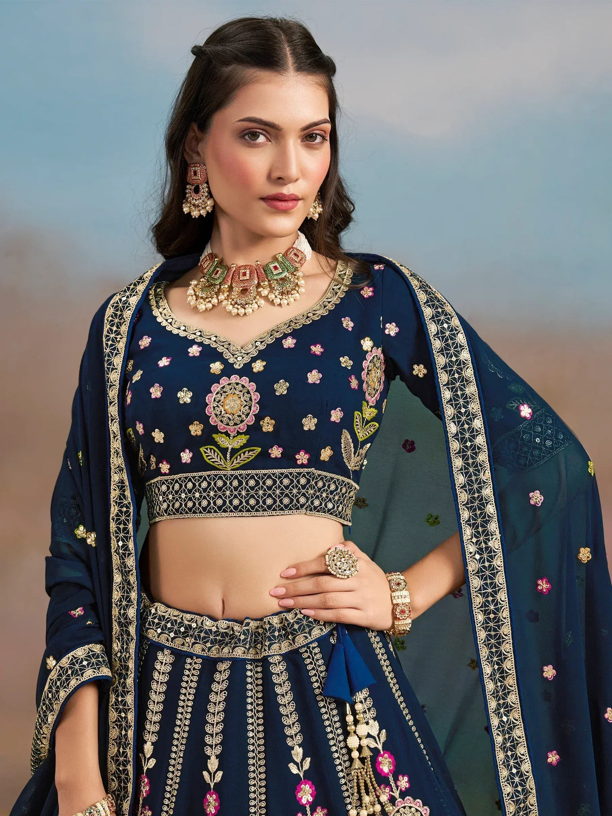 Navy blue embroidered lehenga choli with floral motifs and gold detailing, perfect for Indian ethnic occasions.