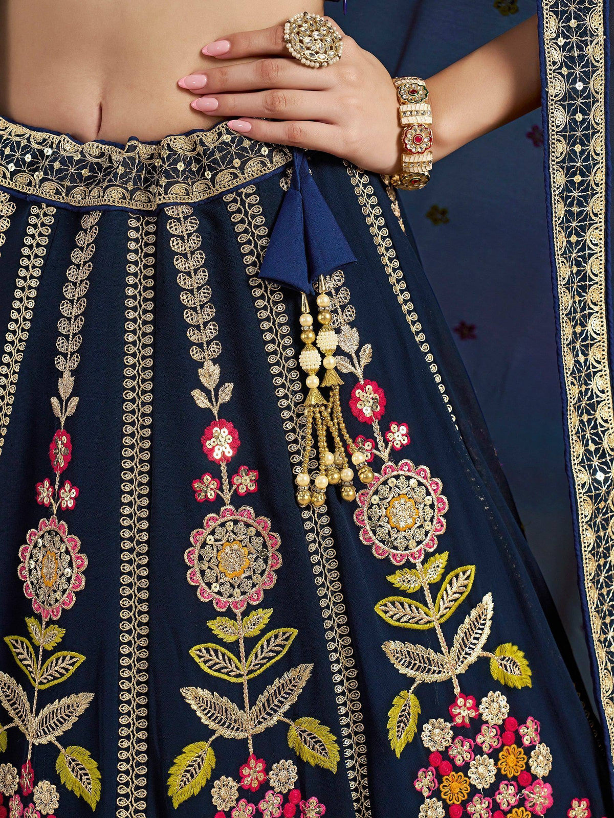 Navy blue lehenga with gold and pink floral embroidery, perfect for Indian ethnic wear occasions.