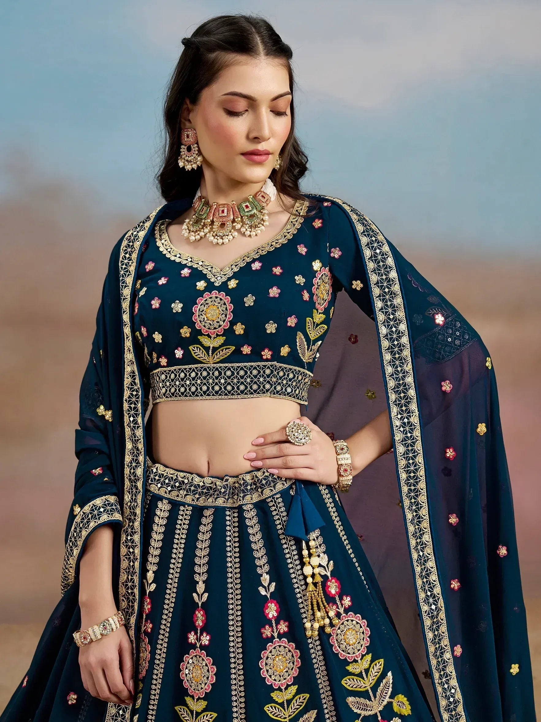 Elegant navy blue embroidered lehenga choli with floral motifs and gold detailing, perfect for Indian ethnic occasions.