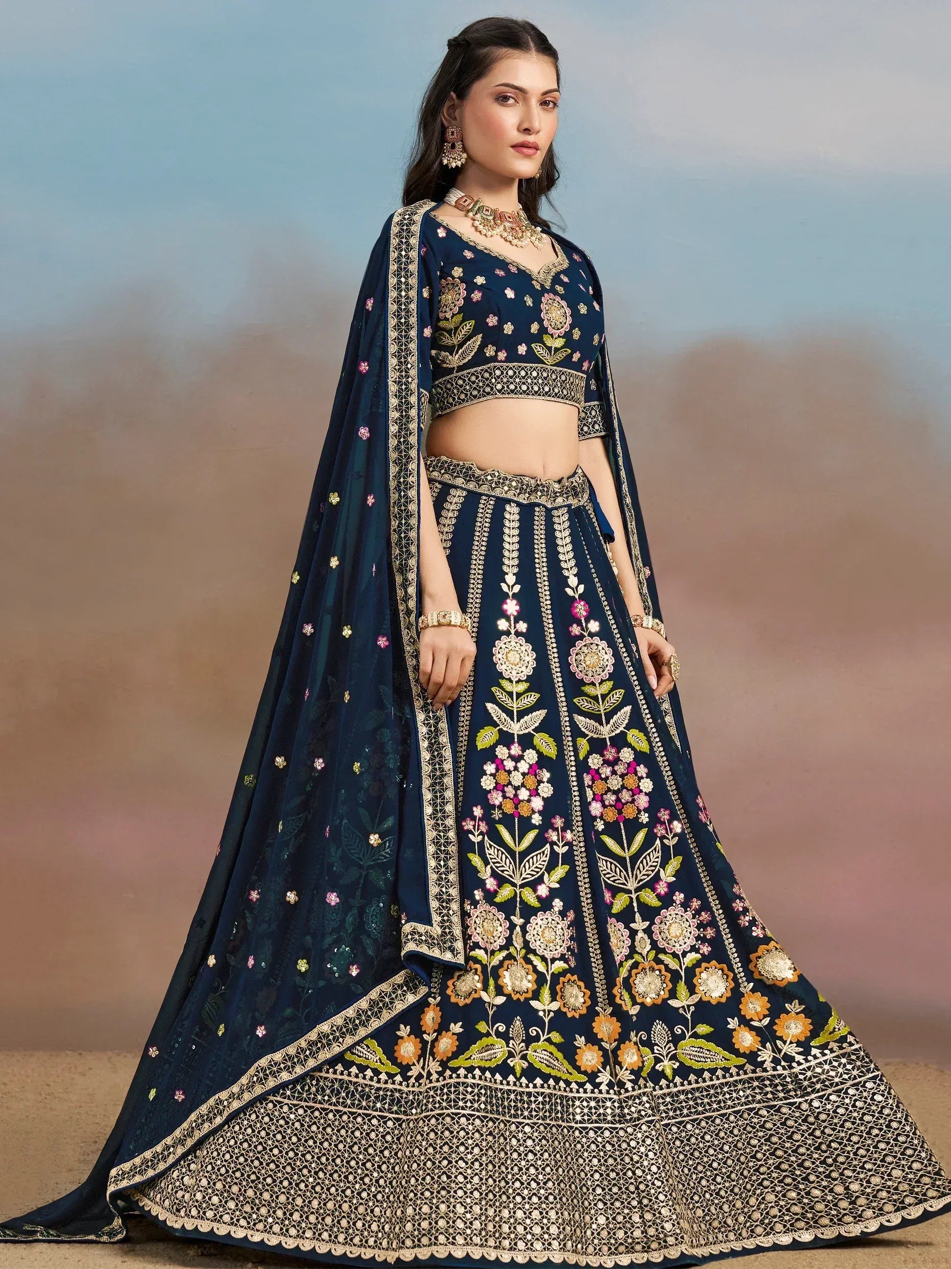 Navy blue embroidered lehenga choli with floral motifs and gold detailing, perfect for Indian ethnic wear occasions.