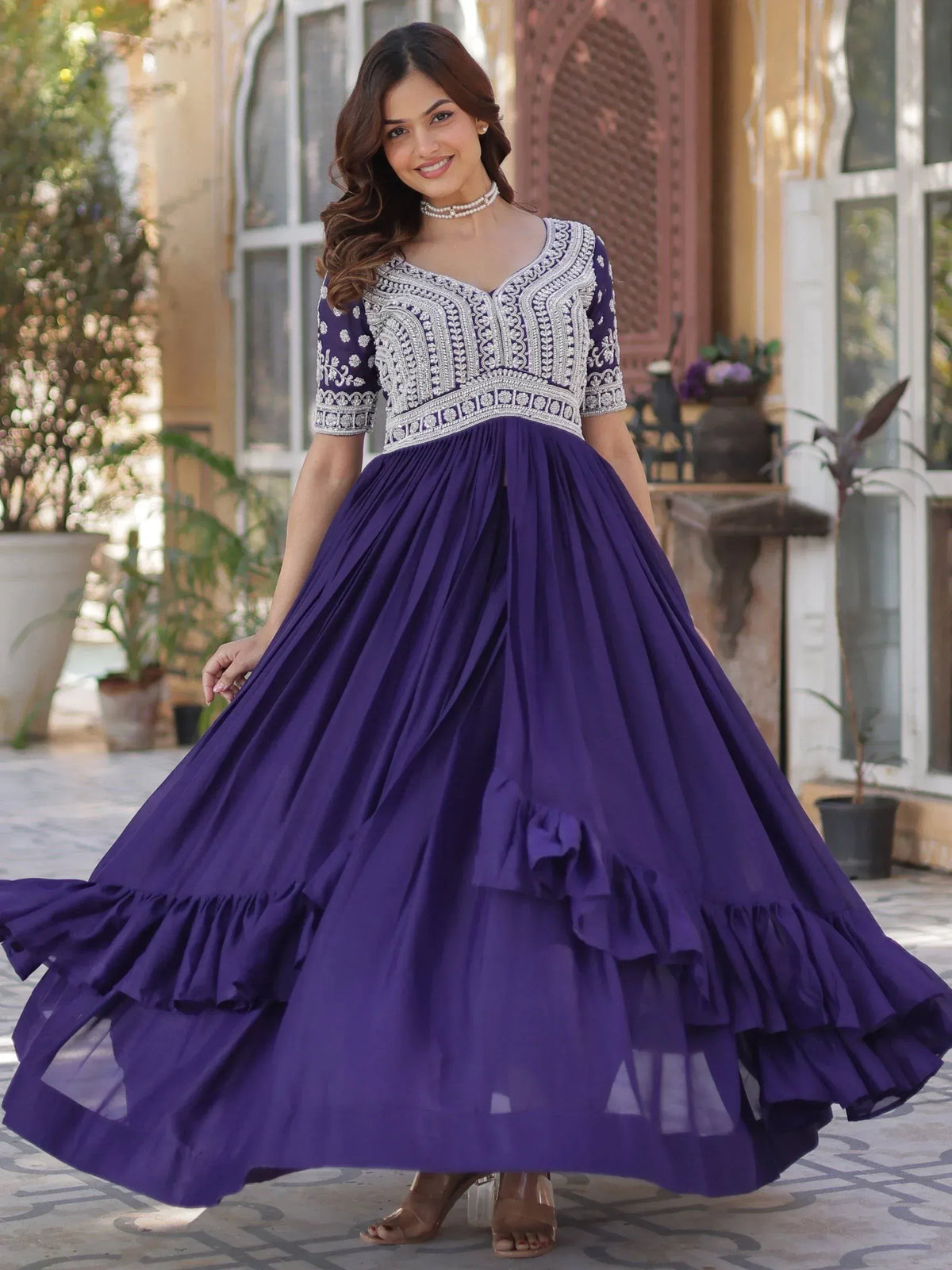 Purple ethnic gown with silver embroidery, pleated skirt, and ruffled hem for festive occasions