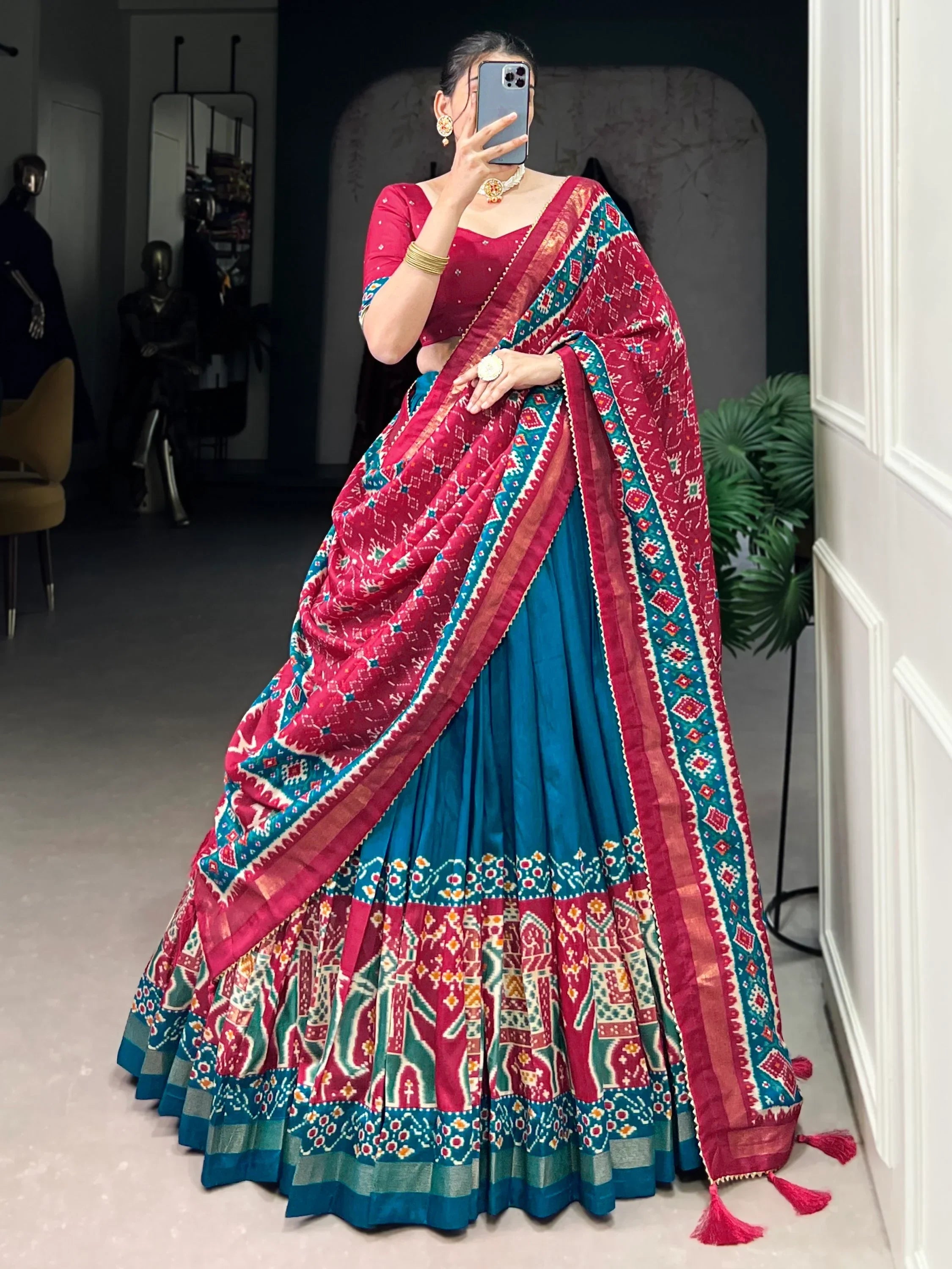 Vibrant red and blue printed lehenga choli with intricate patterns and tassels, perfect for ethnic occasions.