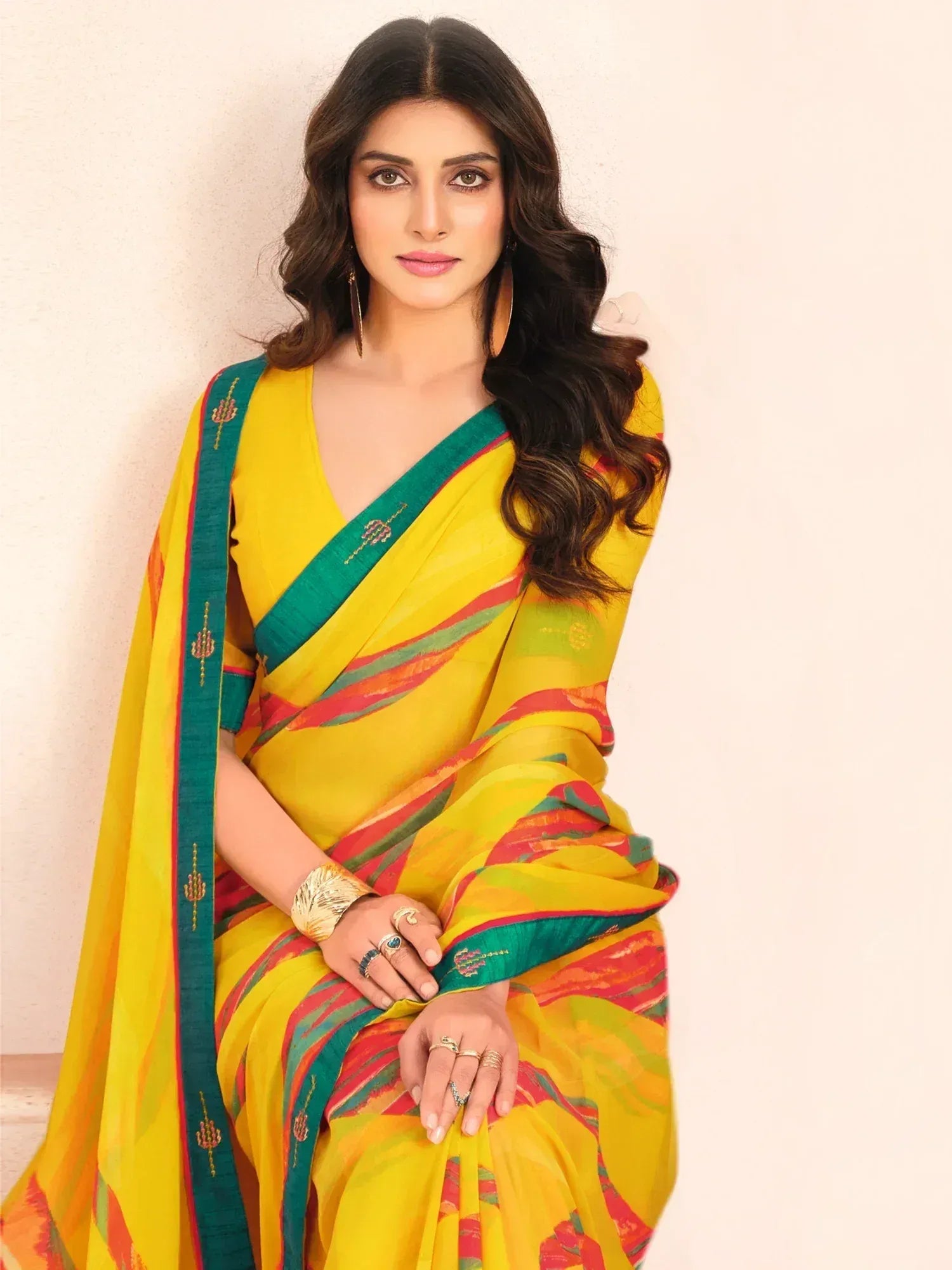 Yellow and green printed saree with embroidered border, styled with gold jewelry for ethnic wear