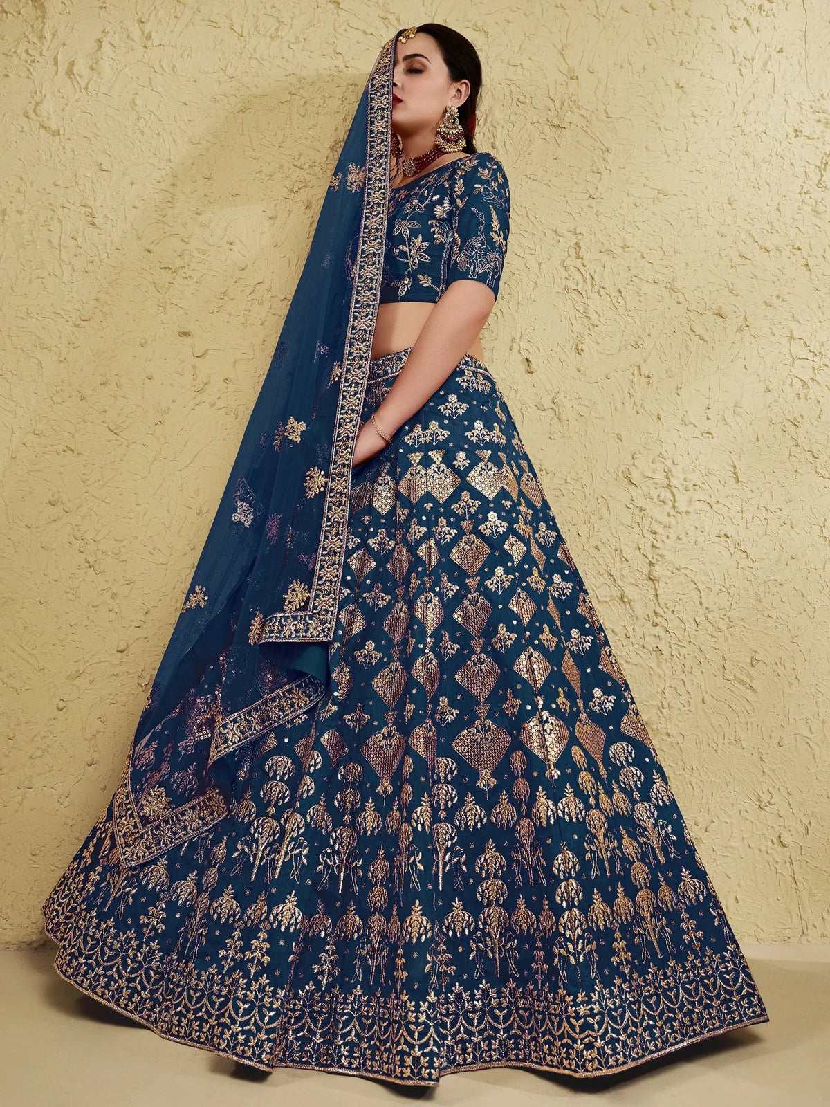 Blue designer lehenga choli with gold embroidery, perfect for Indian weddings and festive occasions.