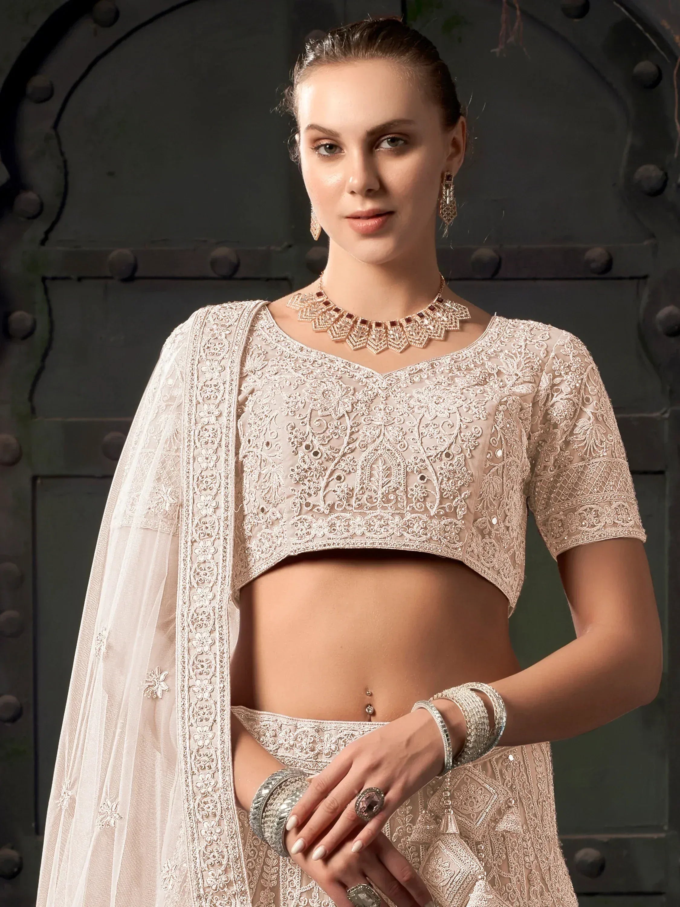 Elegant beige embroidered lehenga choli with sheer dupatta, perfect for Indian weddings and festive occasions.