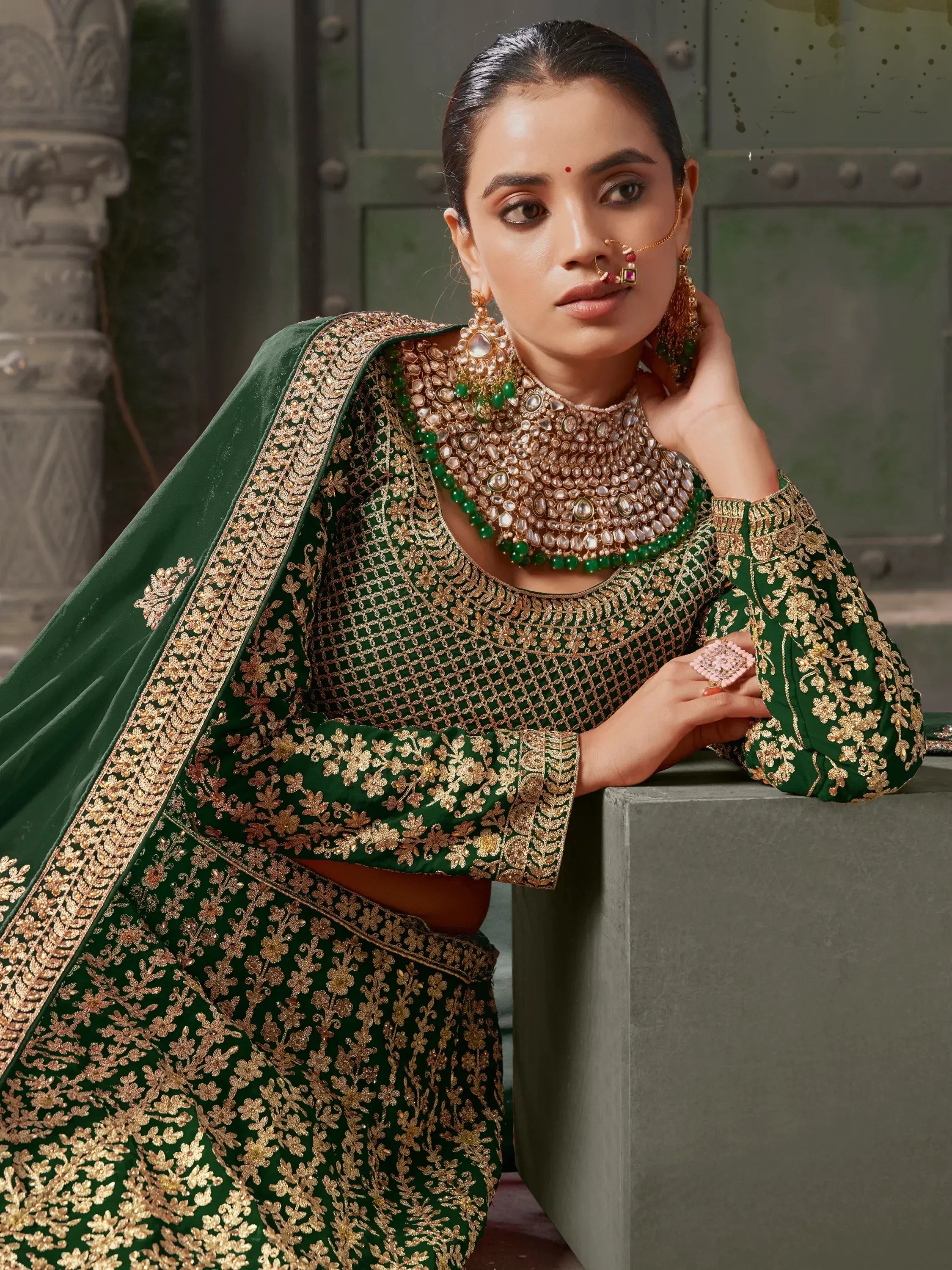 Emerald green designer lehenga choli with gold embroidery and traditional Indian jewelry