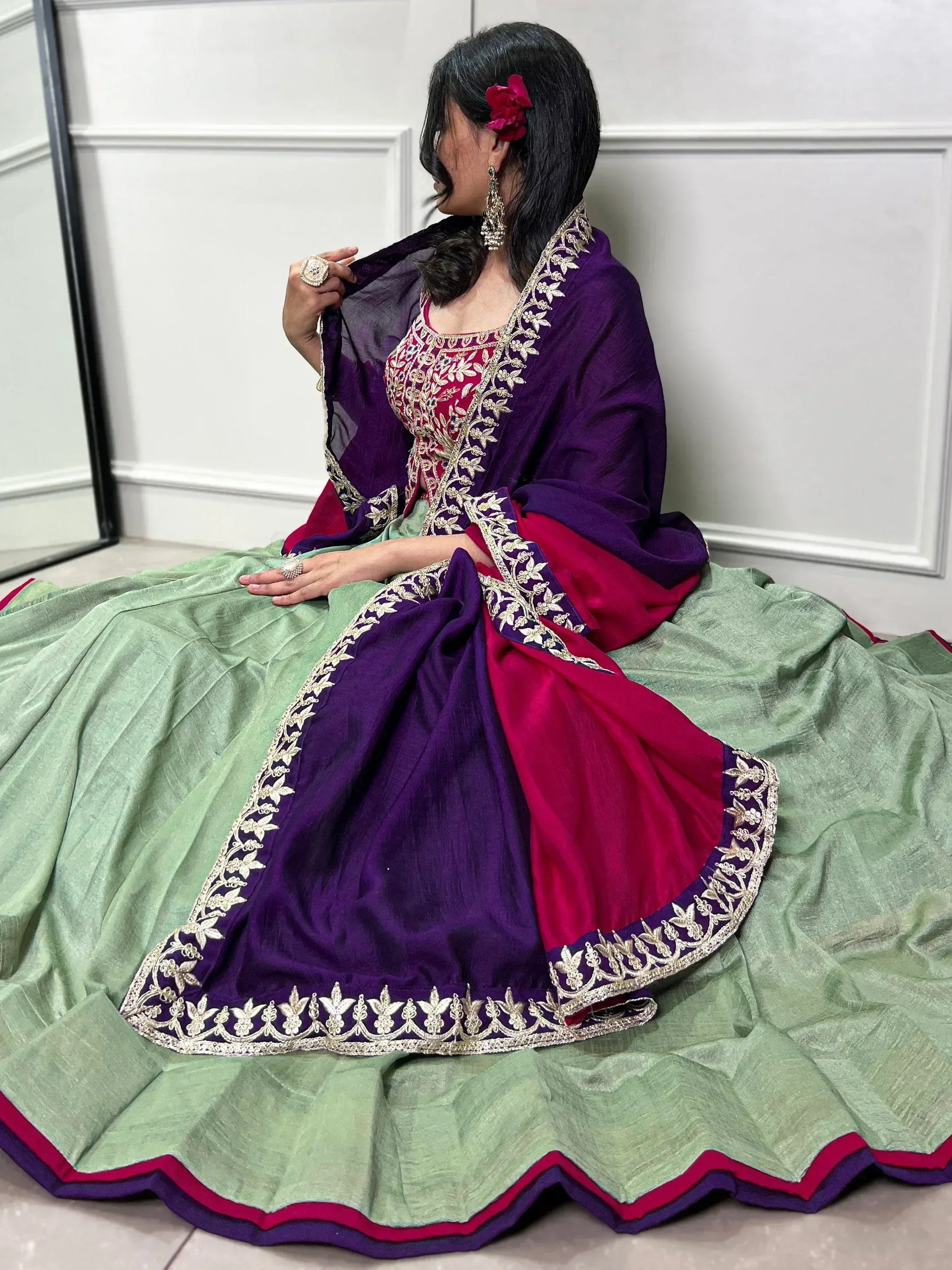 Woman in purple and green designer lehenga choli with gold embroidery, perfect for Indian ethnic wear occasions