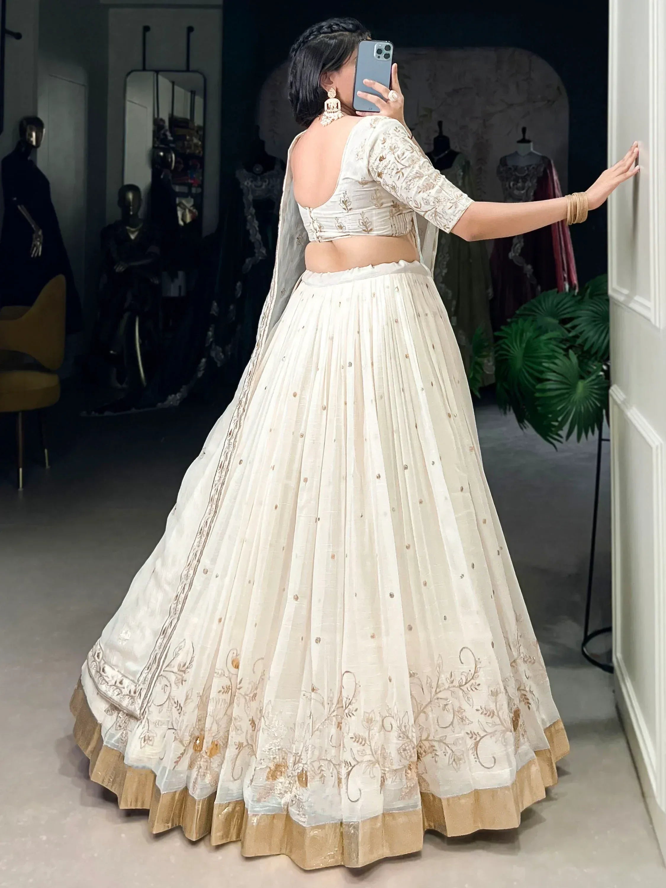 Elegant white lehenga choli with gold embroidery, back view, perfect for Indian weddings or festive occasions