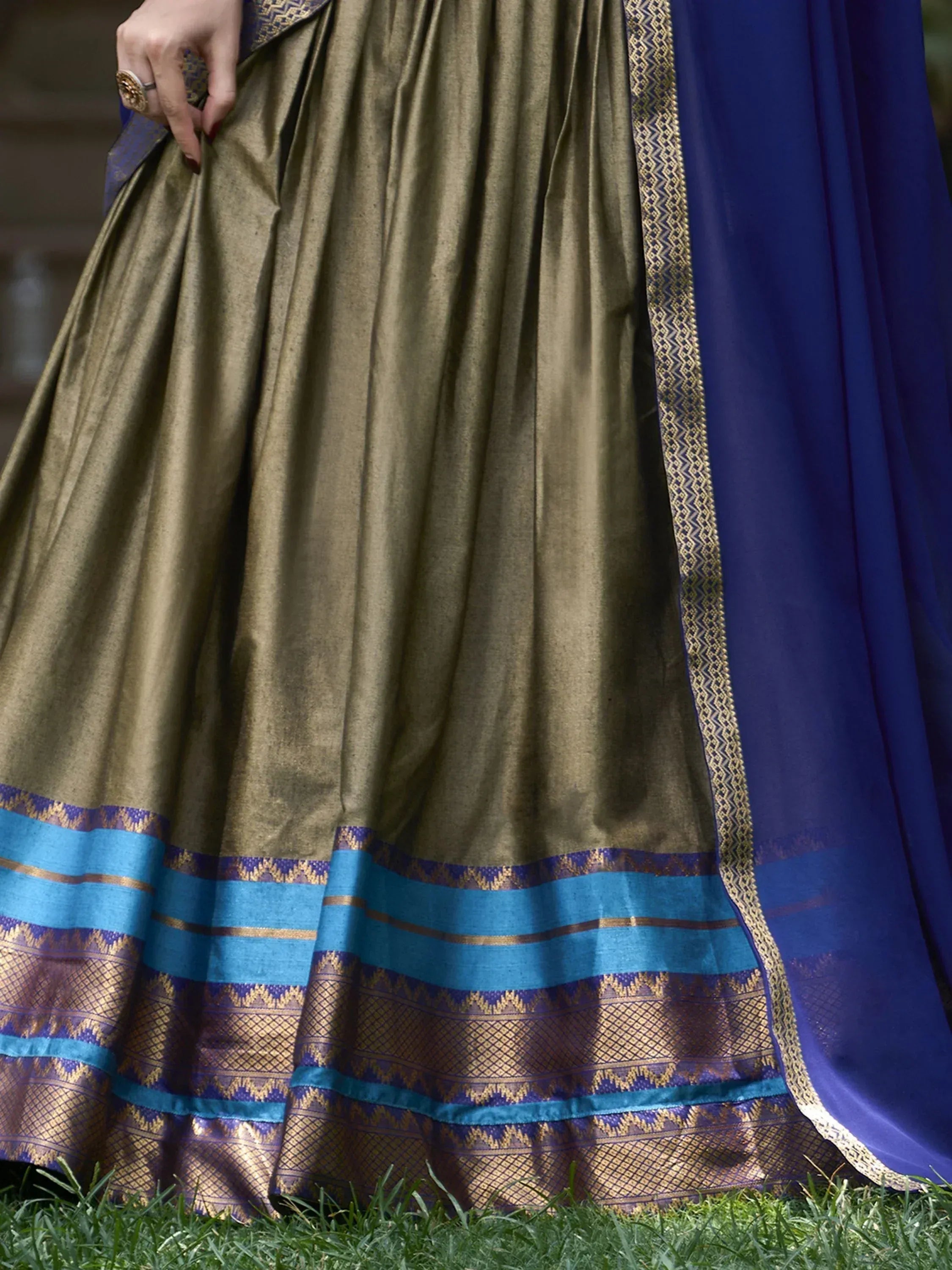 Olive green lehenga with blue and gold border, paired with royal blue dupatta, ethnic wear