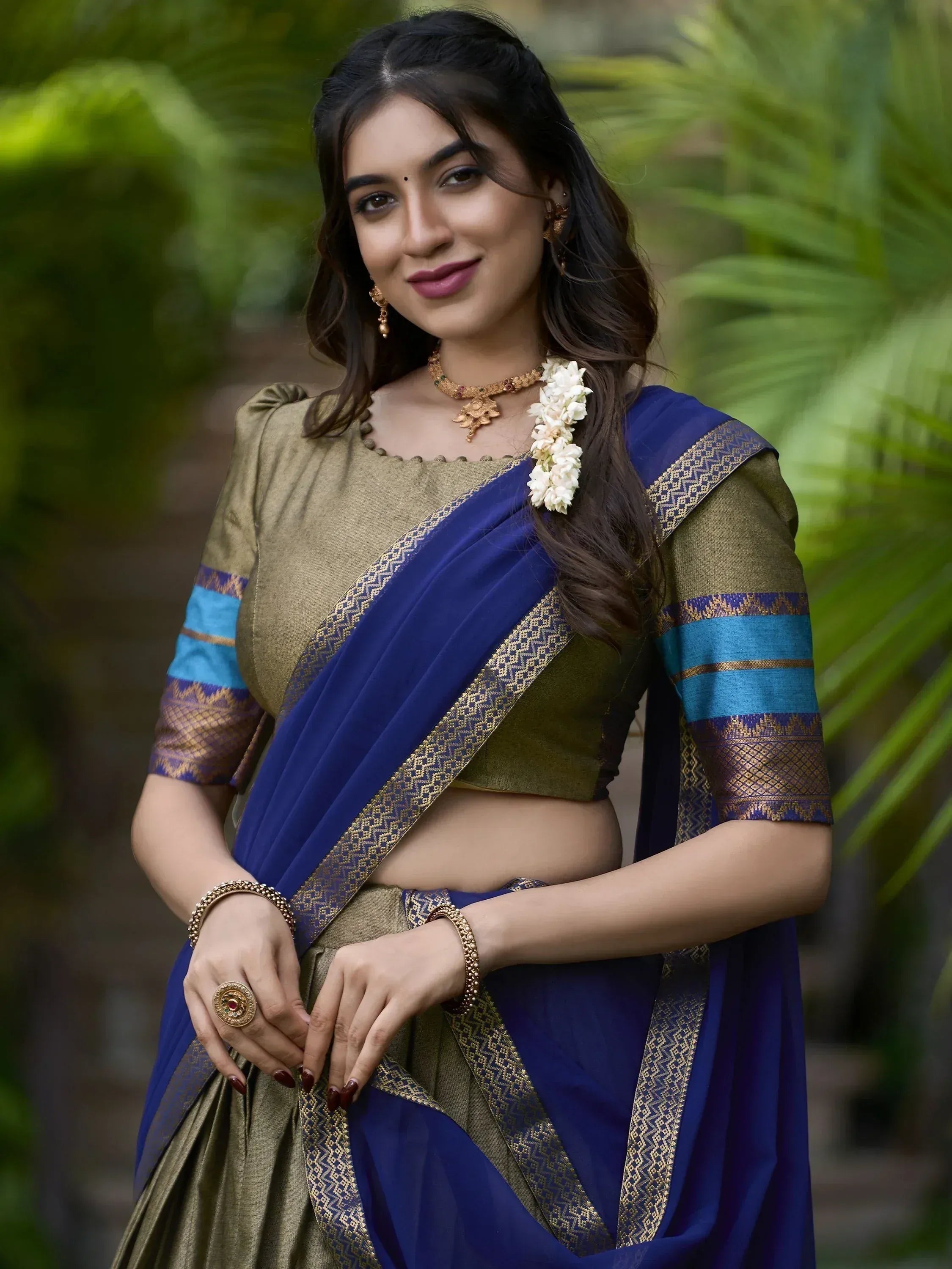 Woman in elegant blue and gold saree with traditional jewelry, perfect for Indian ethnic wear occasions