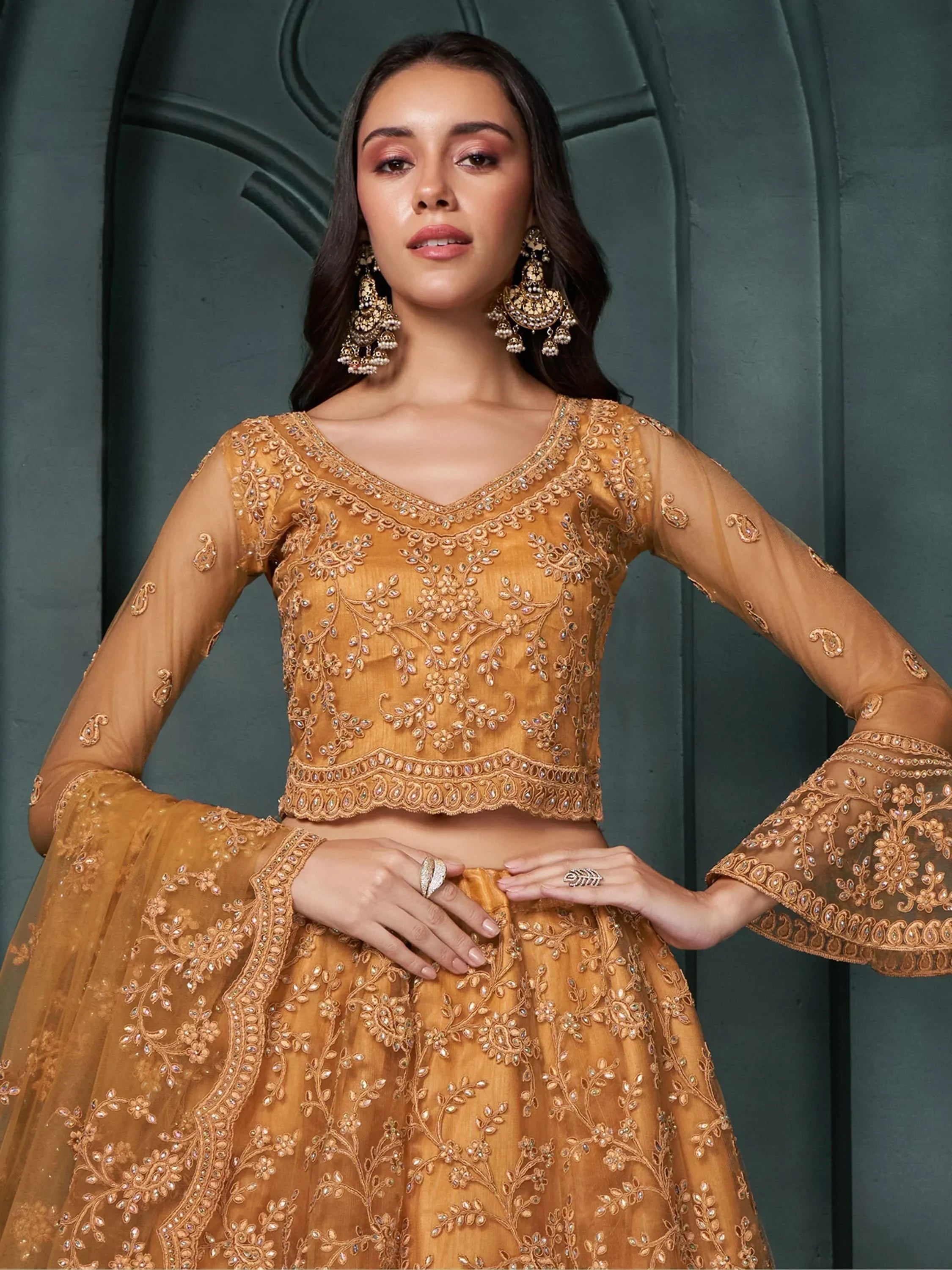 Golden embroidered lehenga choli with sheer bell sleeves, perfect for Indian ethnic wear occasions