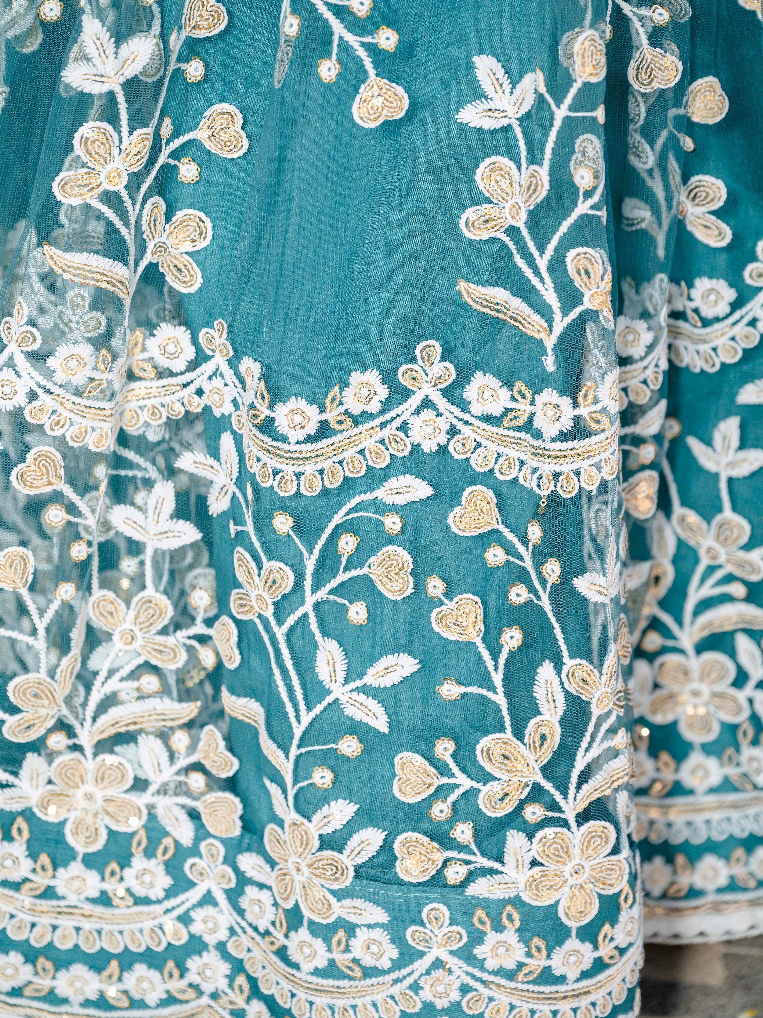Teal ethnic gown with white and gold floral embroidery, perfect for Indian occasions