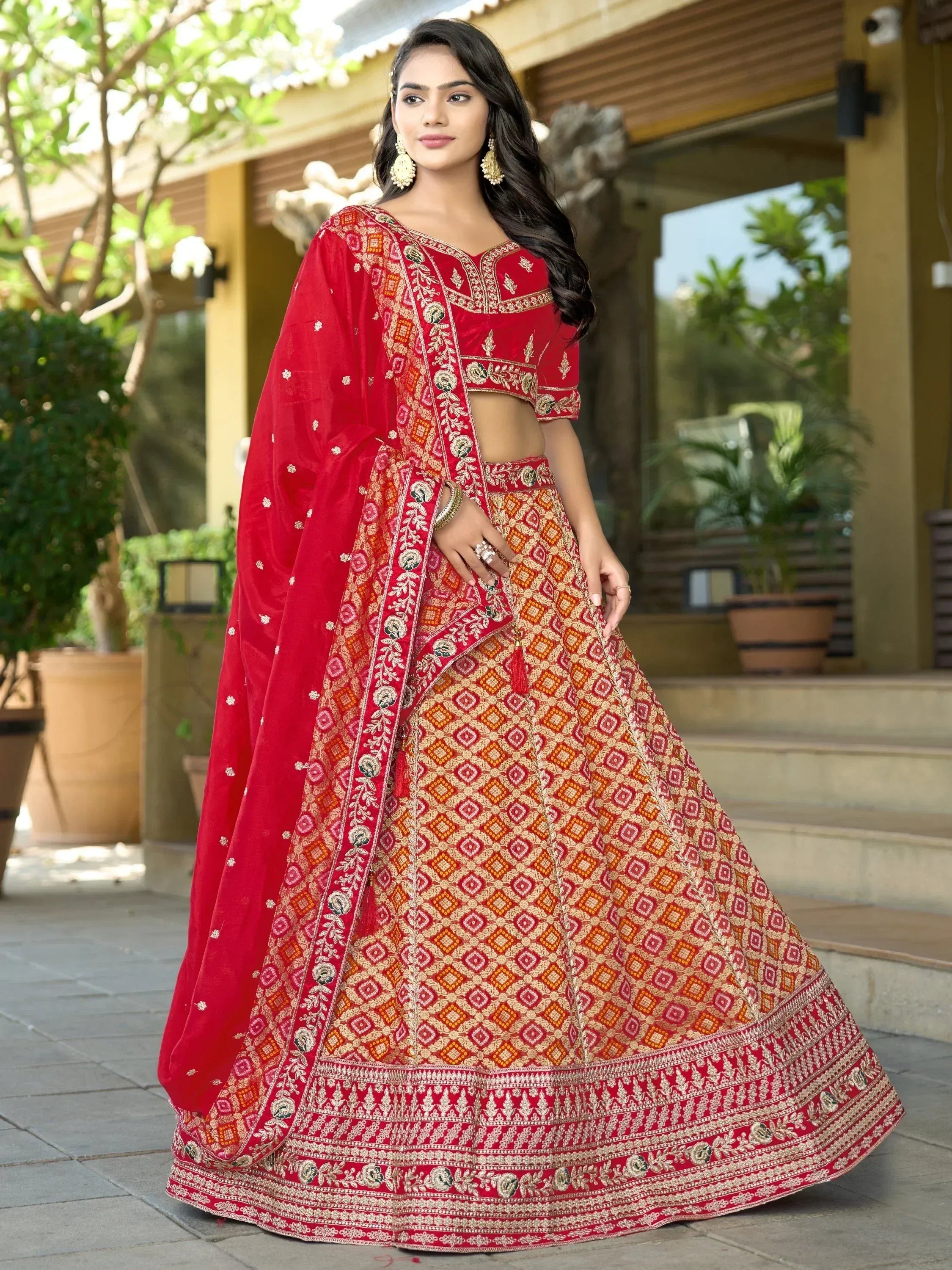 Red embroidered lehenga choli with geometric patterns, perfect for Indian weddings and festive occasions.