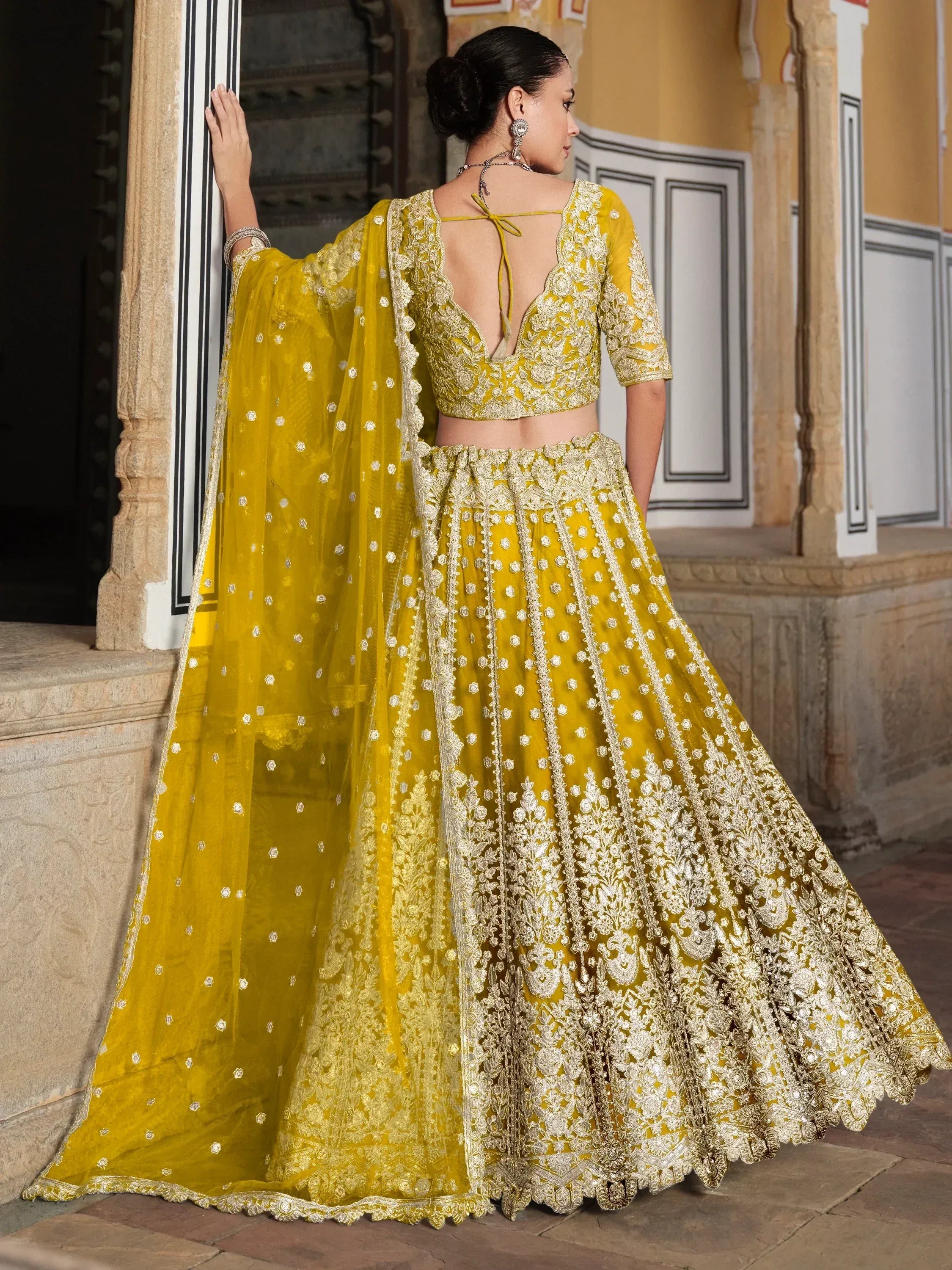 Yellow designer lehenga choli with gold embroidery, perfect for Indian weddings and festive occasions.