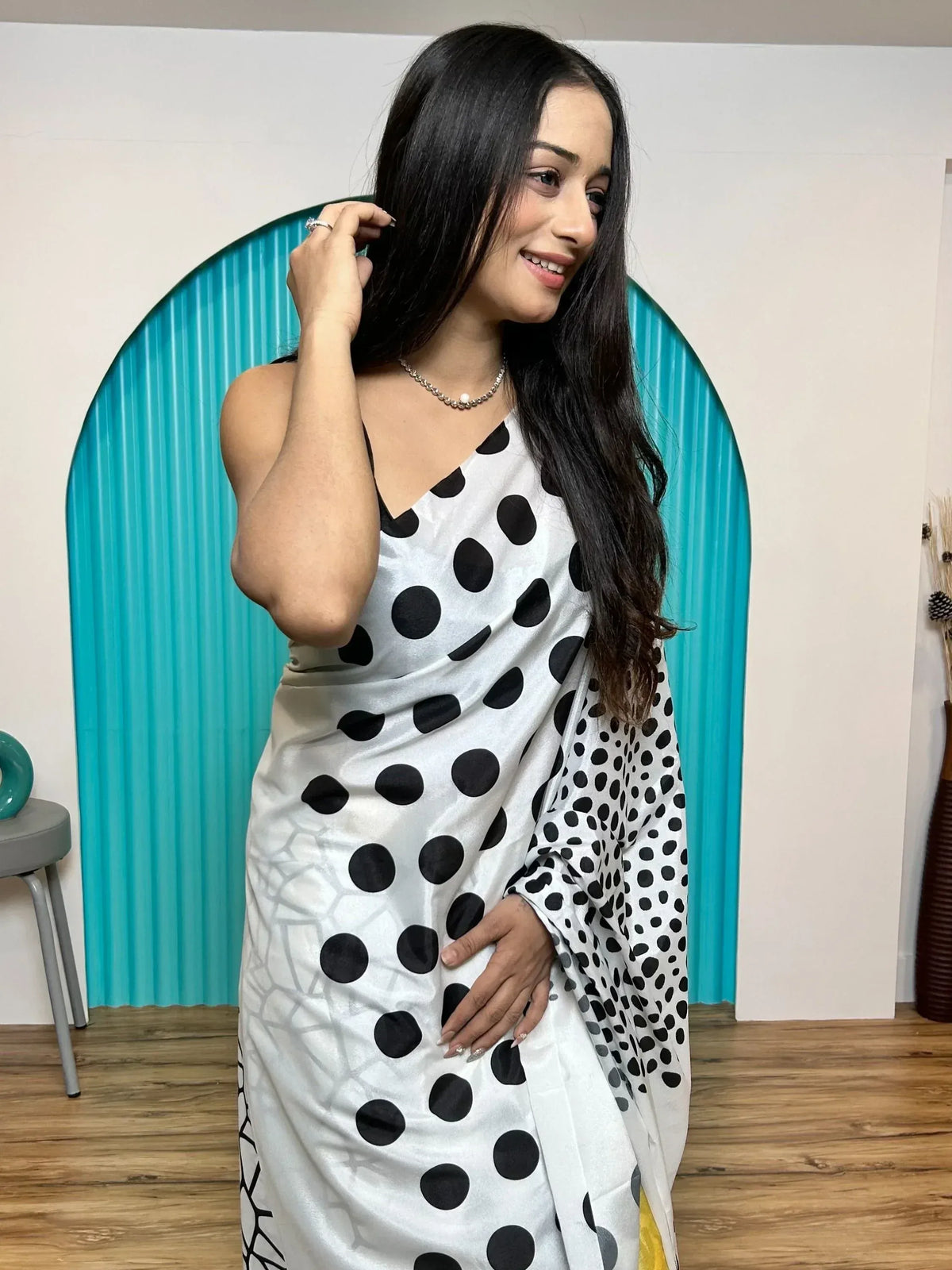 Woman in white saree with black polka dots, elegant ethnic wear for special occasions