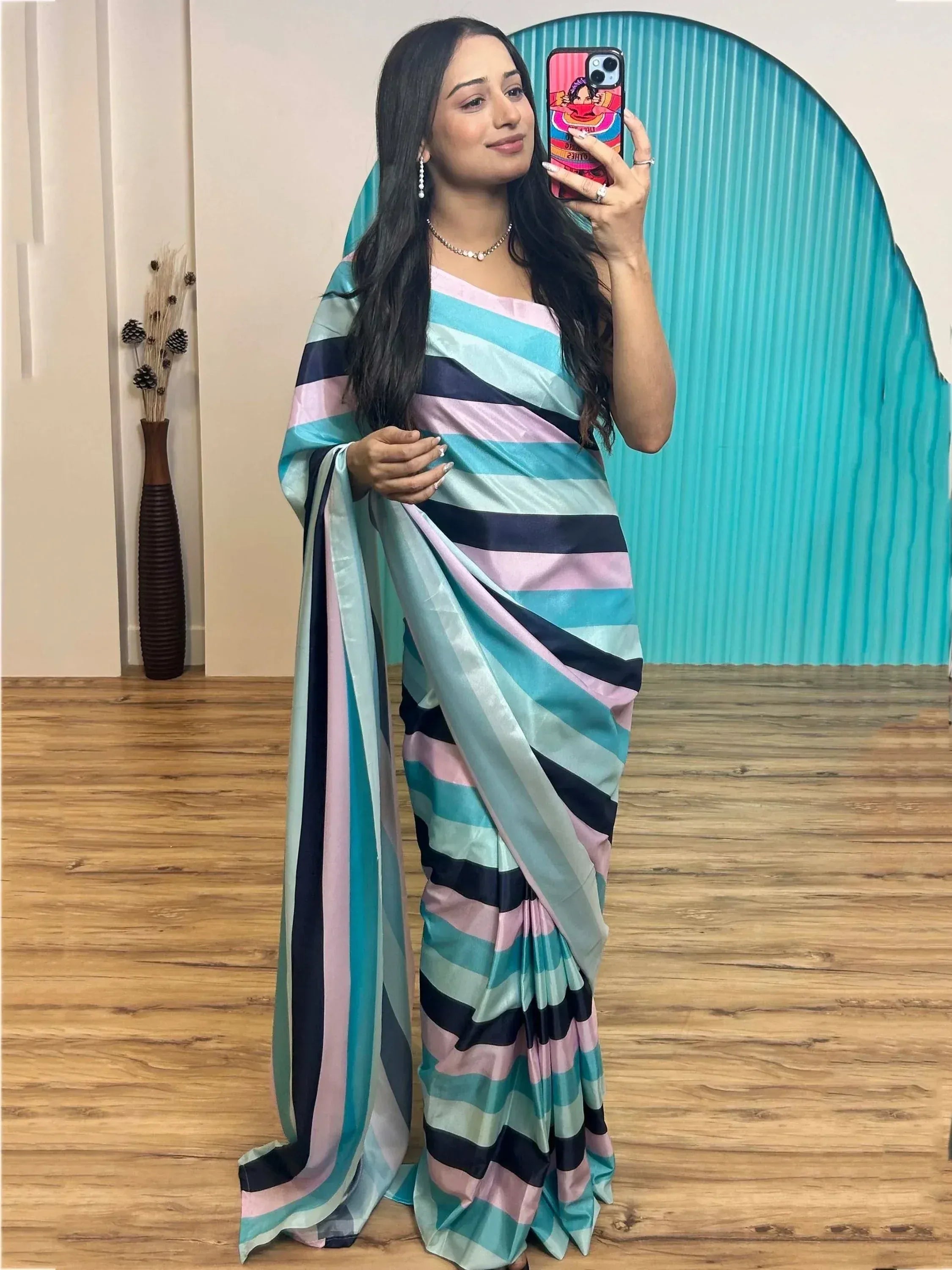 Woman in colorful striped saree taking mirror selfie, stylish ethnic wear