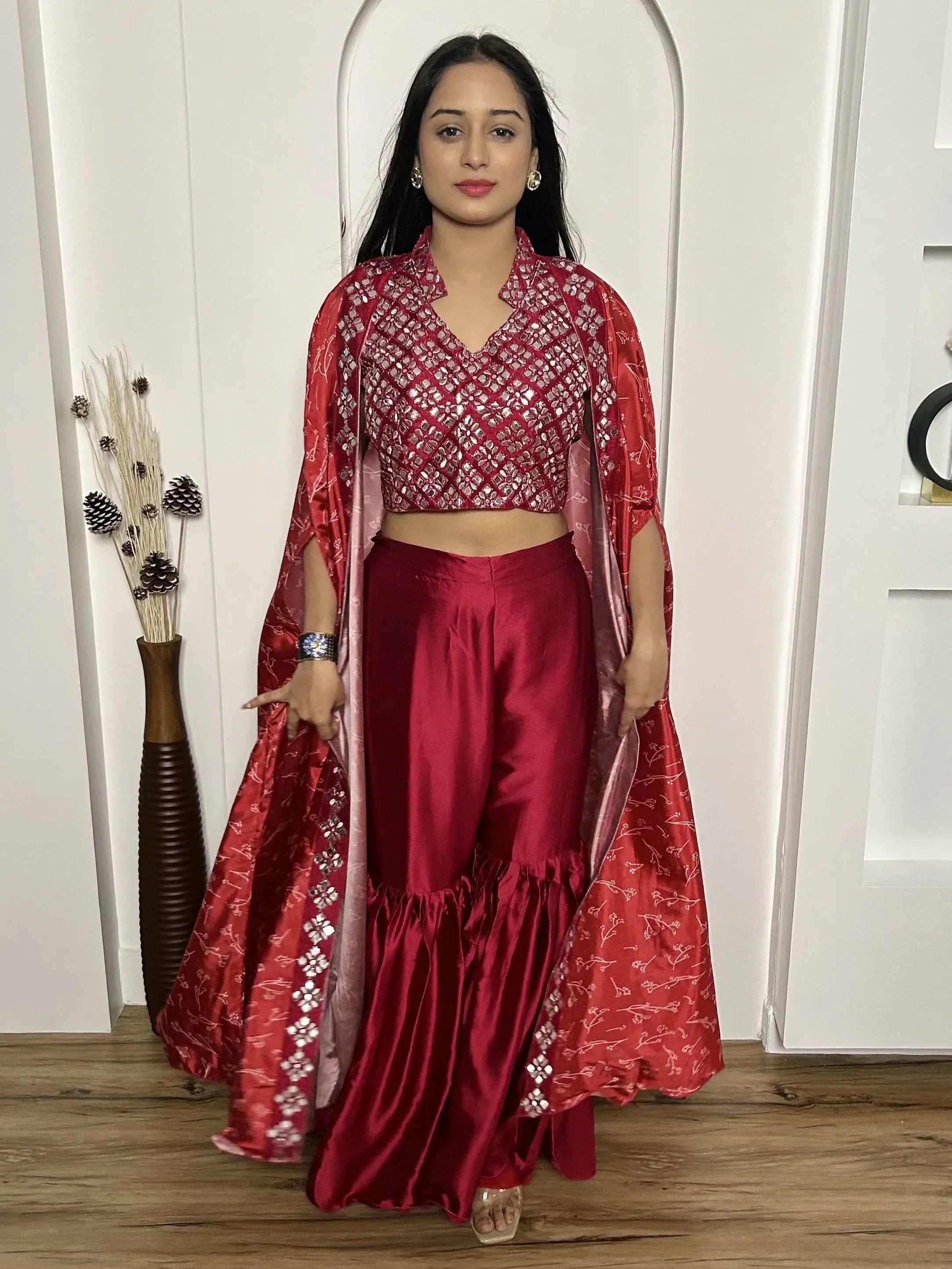Red ethnic palazzo set with mirror work crop top and floral cape, perfect for Indian occasions