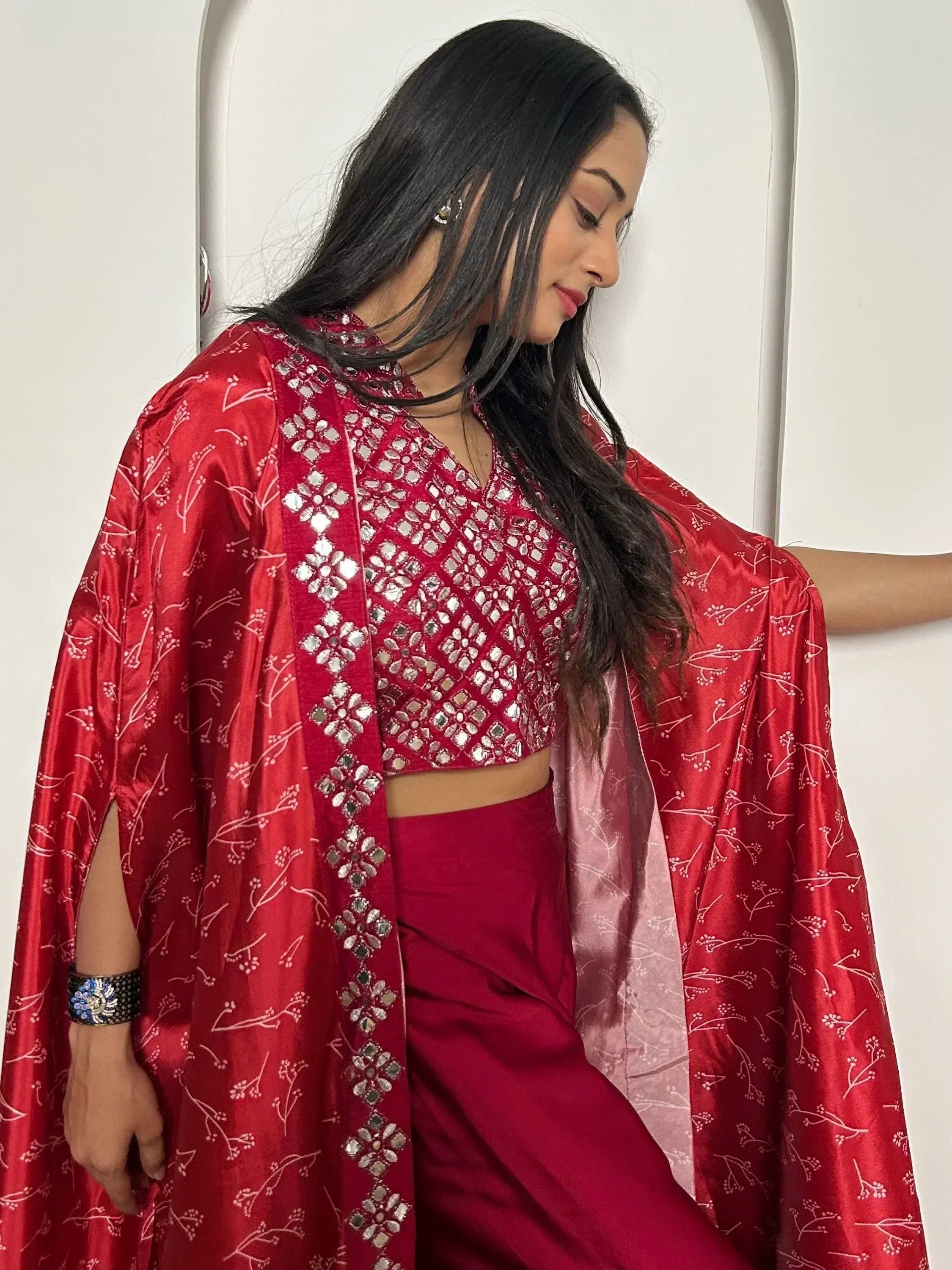 Red ethnic crop top with mirror work, floral cape, and palazzo pants for festive occasions