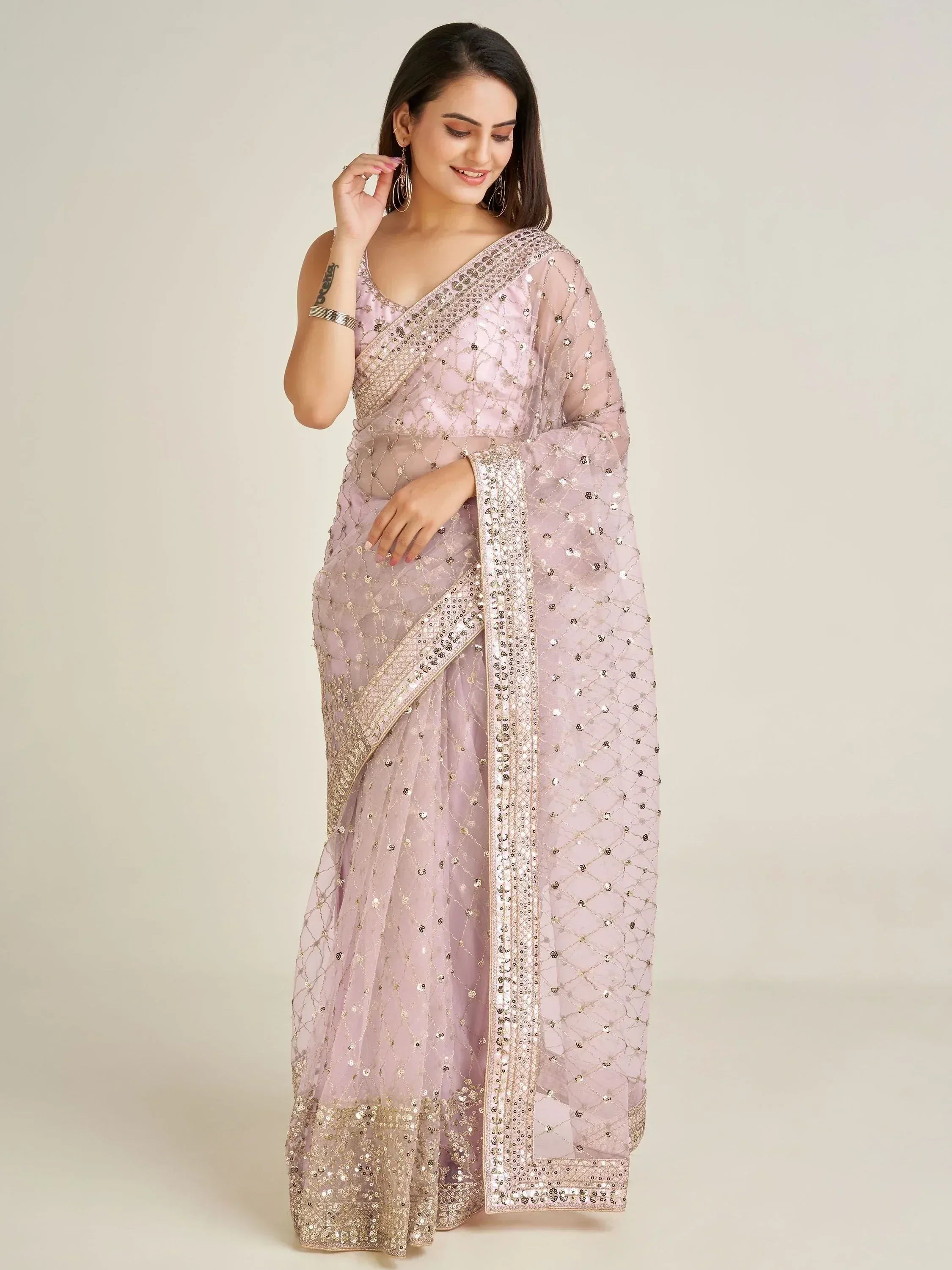 Elegant light pink saree with gold sequin embroidery and sheer overlay, perfect for Indian ethnic occasions.