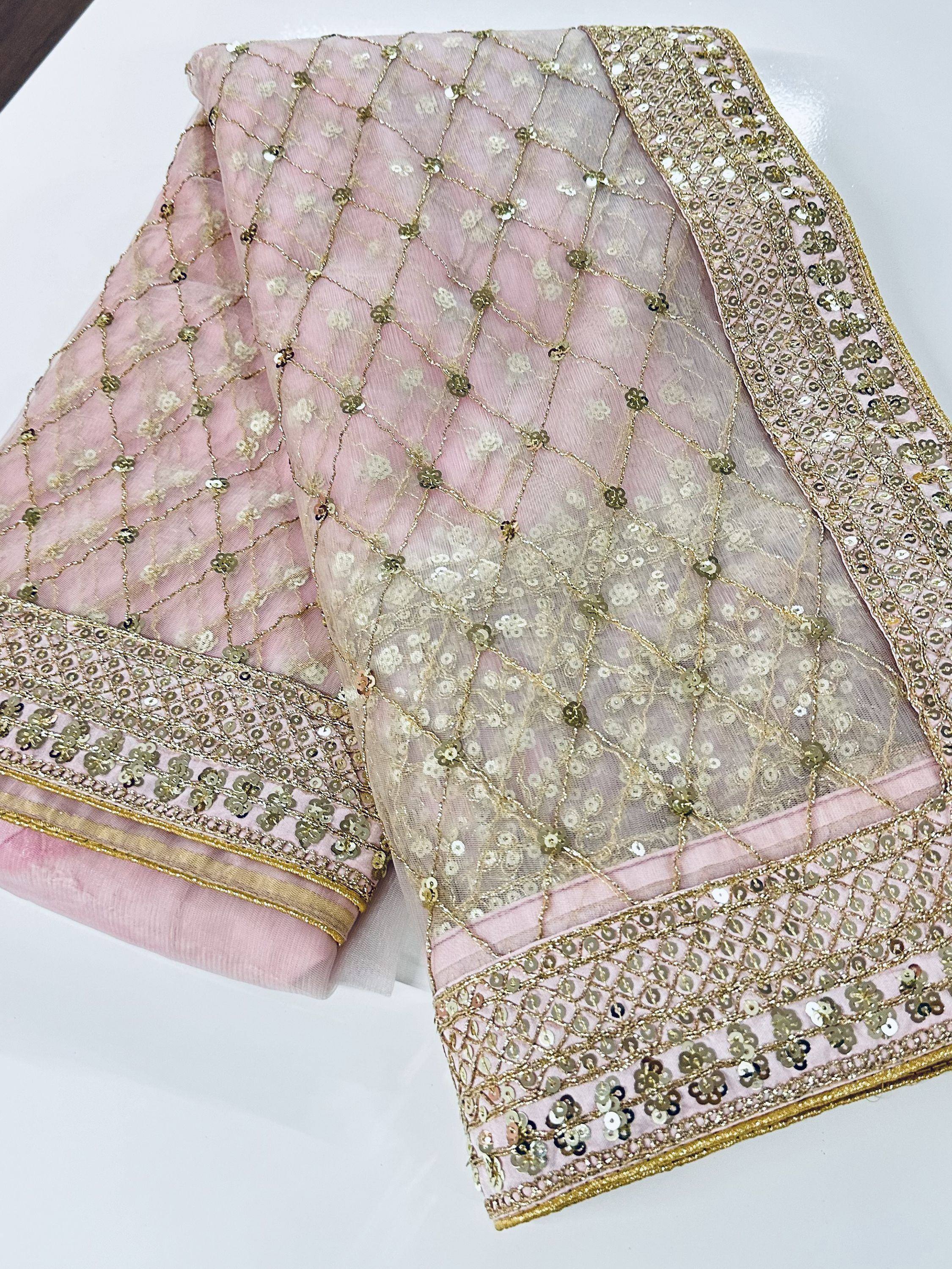 Pink sheer saree with gold sequin embroidery and floral border, ideal for ethnic wear