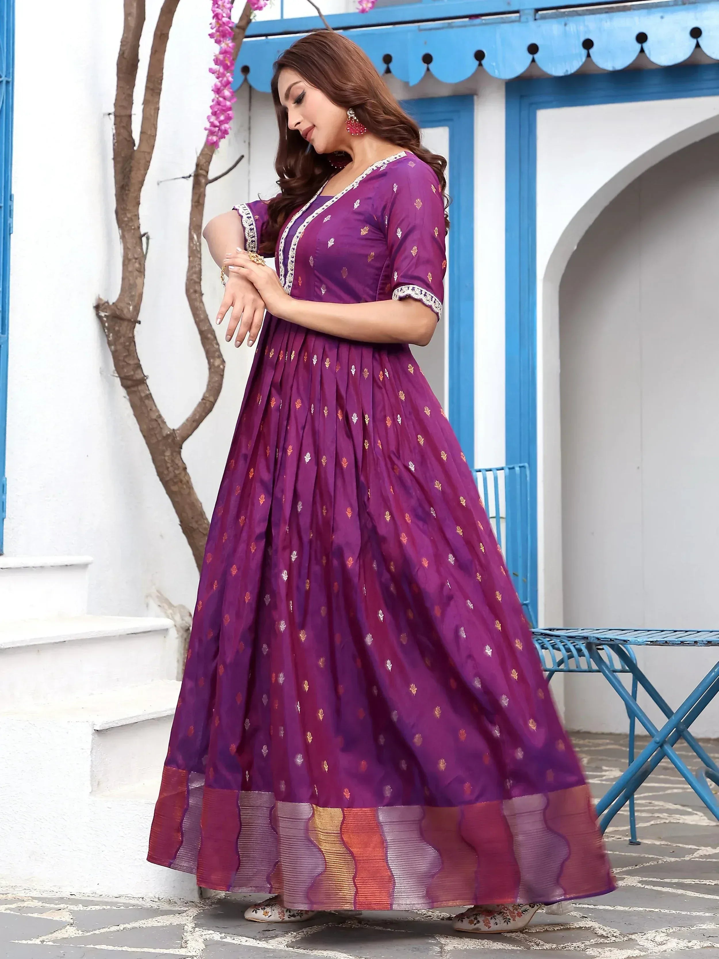 Purple ethnic gown with gold motifs and scalloped border, perfect for Indian occasions
