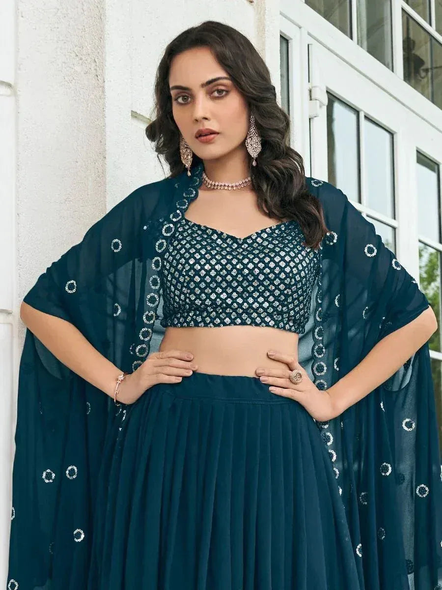 Teal designer lehenga choli with embroidered blouse and sheer dupatta, perfect for ethnic occasions