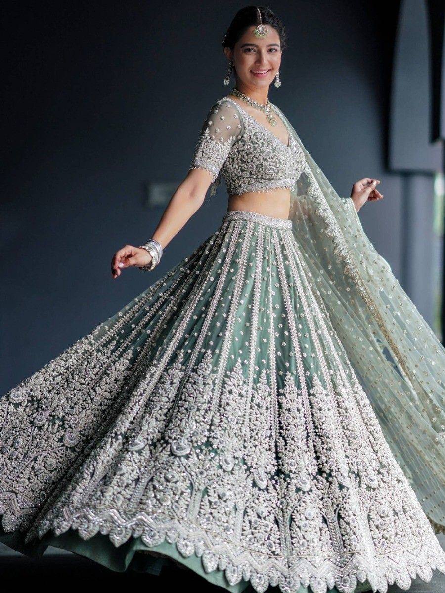 Elegant mint green lehenga choli with heavy silver embroidery and sheer dupatta, perfect for Indian weddings.