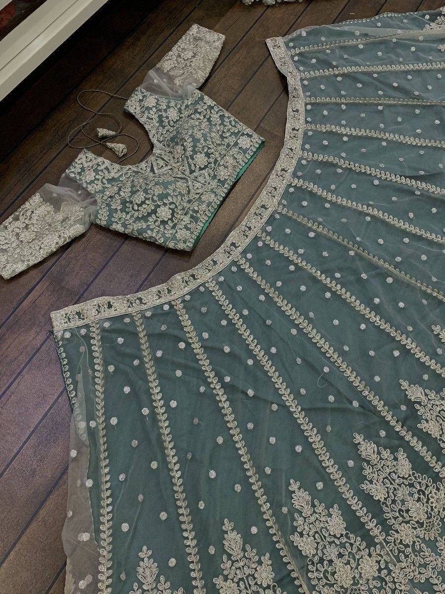 Teal designer lehenga choli with intricate silver embroidery and floral patterns, perfect for Indian ethnic wear.